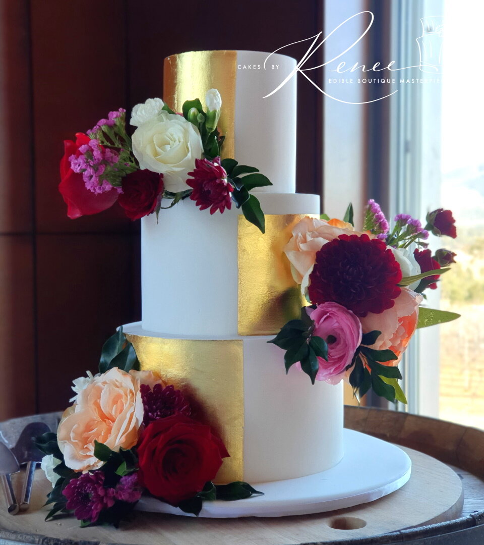 3 tier gold wedding cake fresh flowers gold leaf