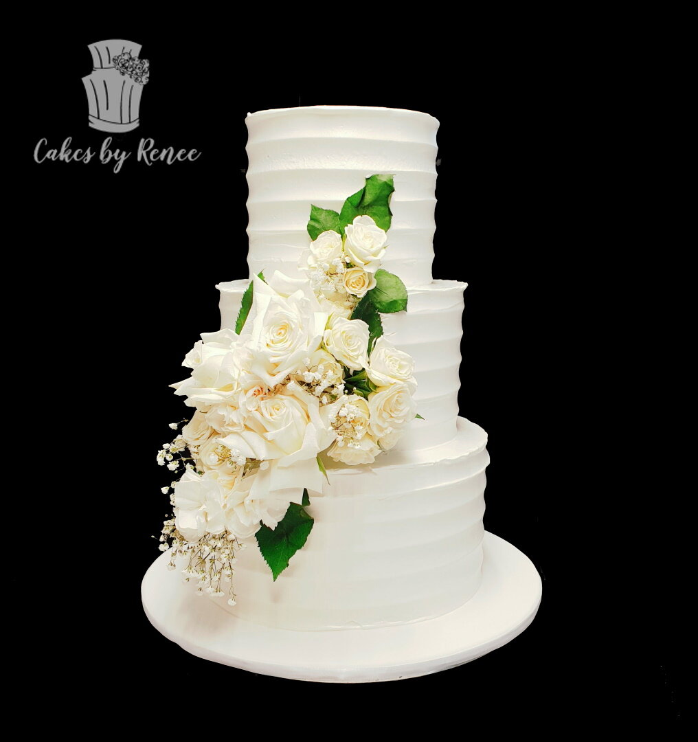 3 tier white wedding cake comb finish fresh flowers buttercream
