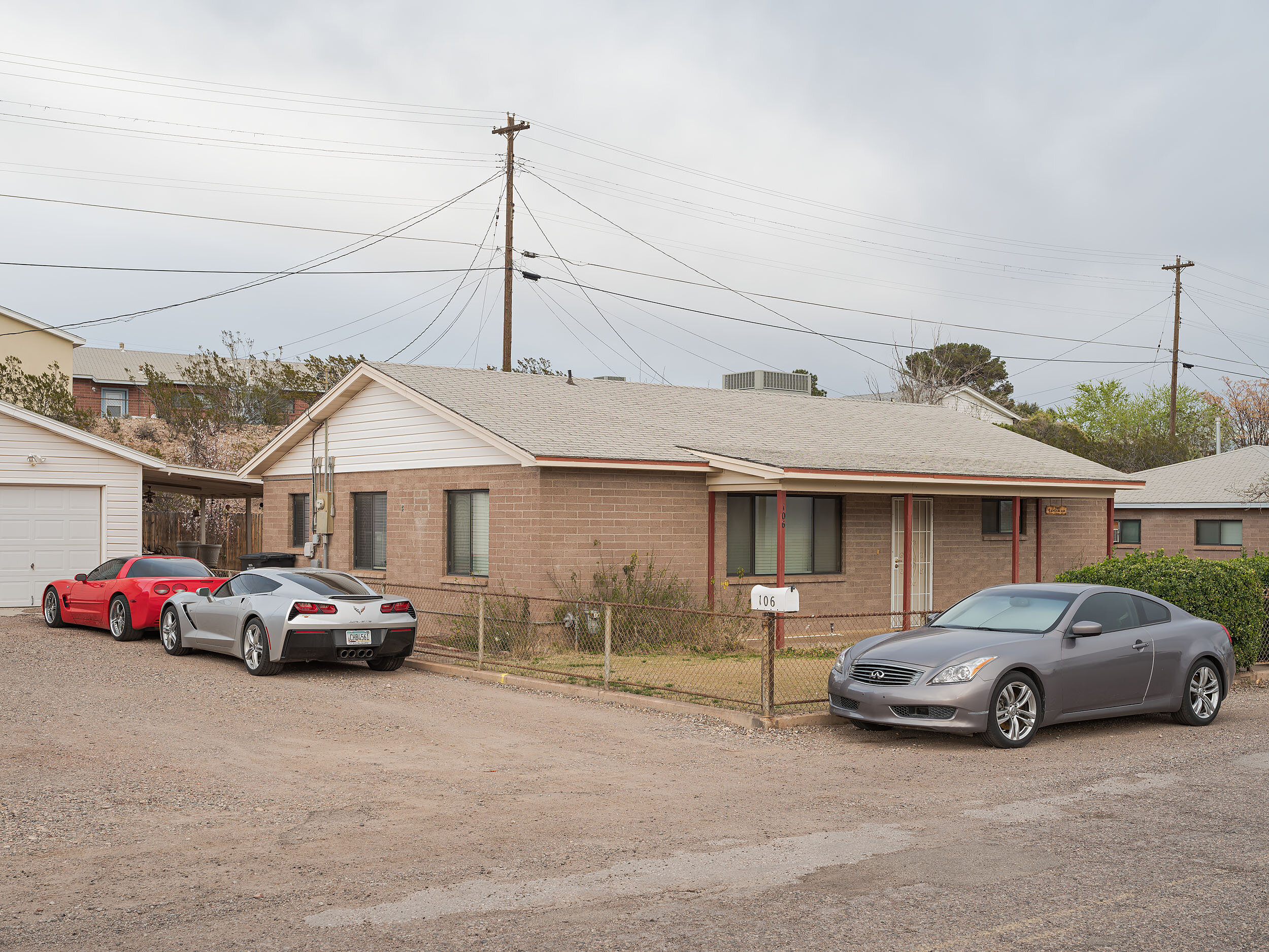  Muscle and luxury cars, parked at a Freeport-McMoran Morenci Home. The phrase "Morenci Rich" was used to describe a phenomena of excess spending given the high wages and low cost of living for mine workers. 