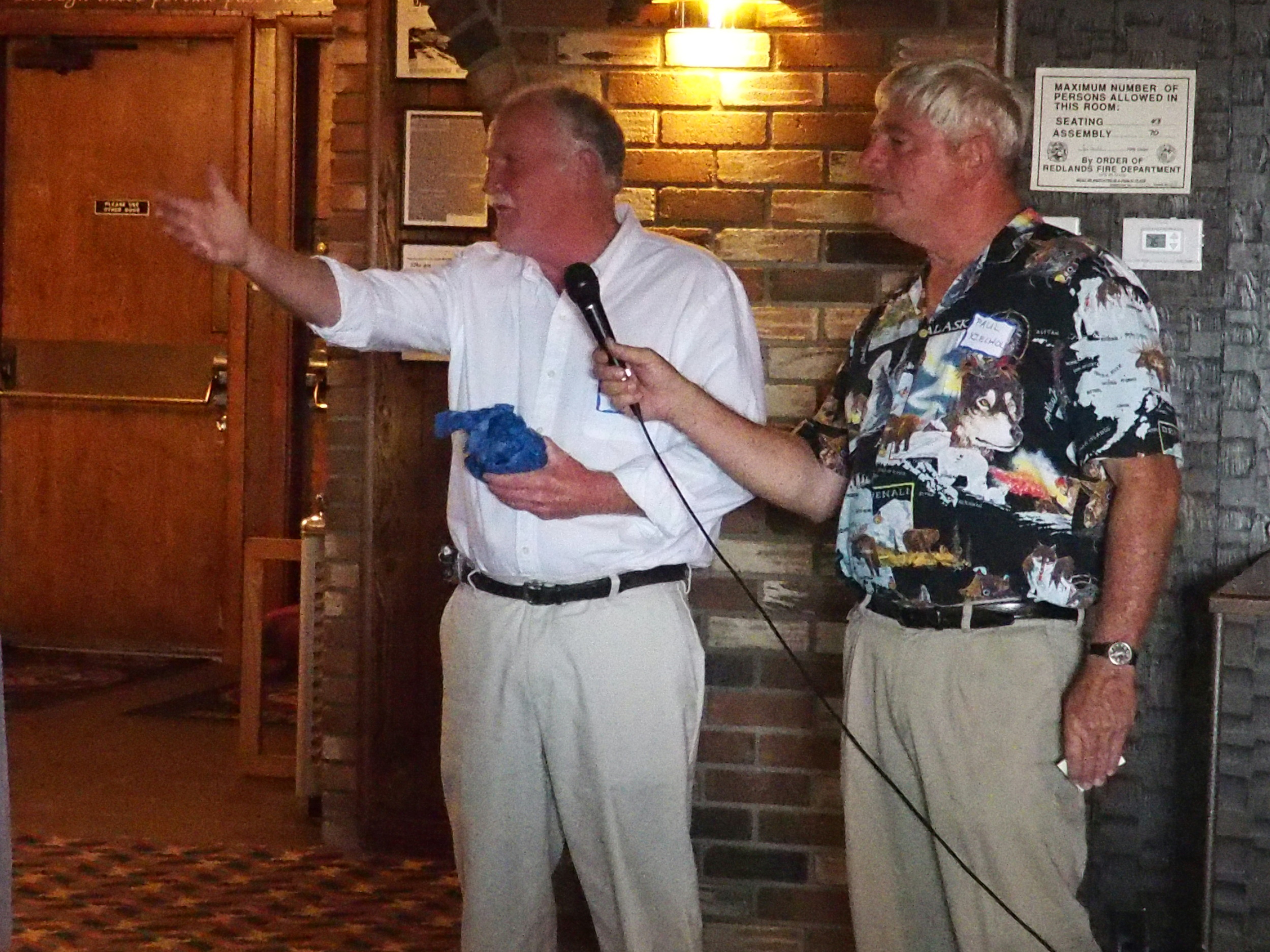 John McKay (with emcee Paul Kielhold) being acknowledged for traveling the farthest
