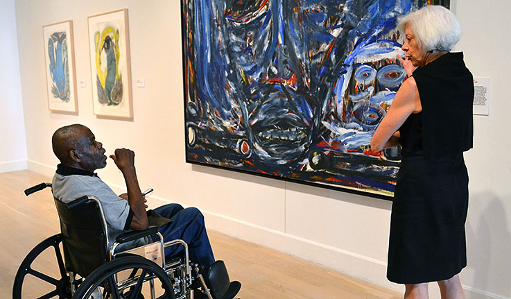 Willie Young view an installation of Thornton Dial's The Reservoir (1990) with Weatherspoon Museum Director Nancy Doll last summer.