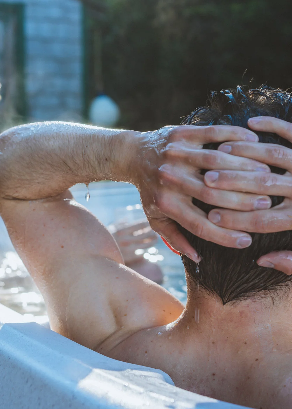 Man relaxing in jacuzzi dripping wet