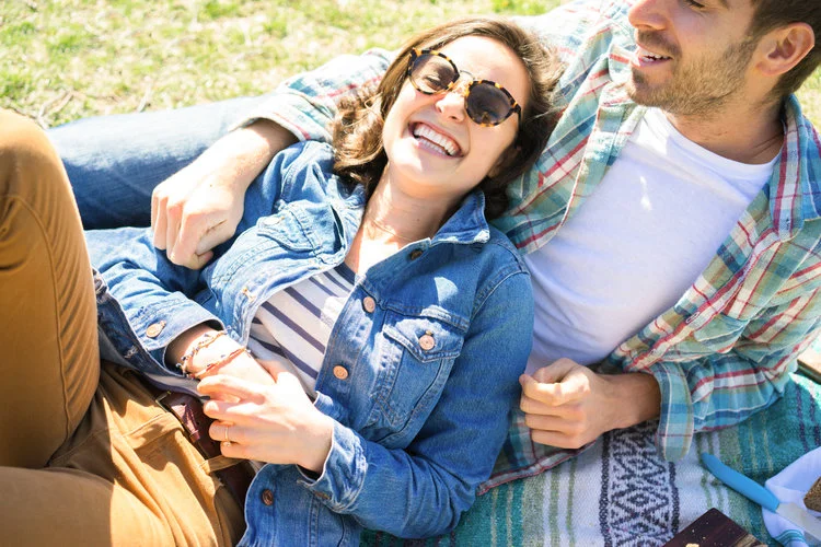 Young couple cuddling at the park smiling