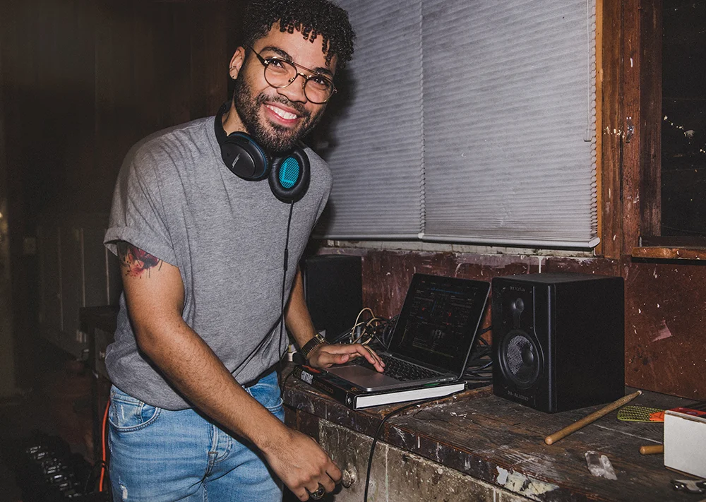 African-american man smiling making music on computer