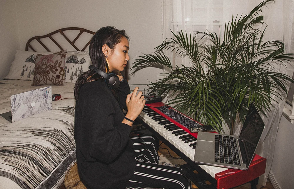 Young woman playing piano in her bedroom