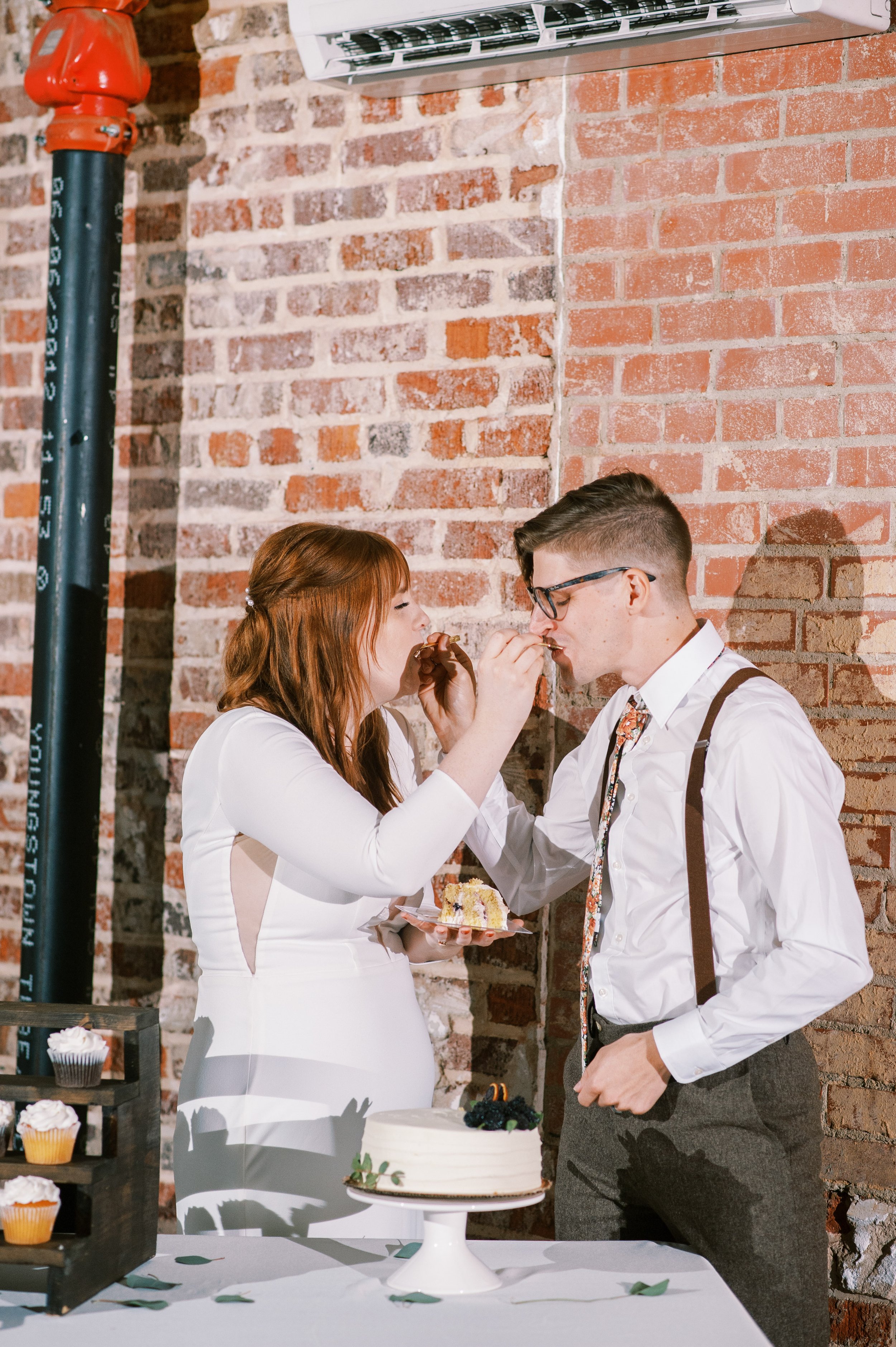 Cake Eating Bride and Groom Wedding at The Bottle Factory Monroe NC Fancy This Photography