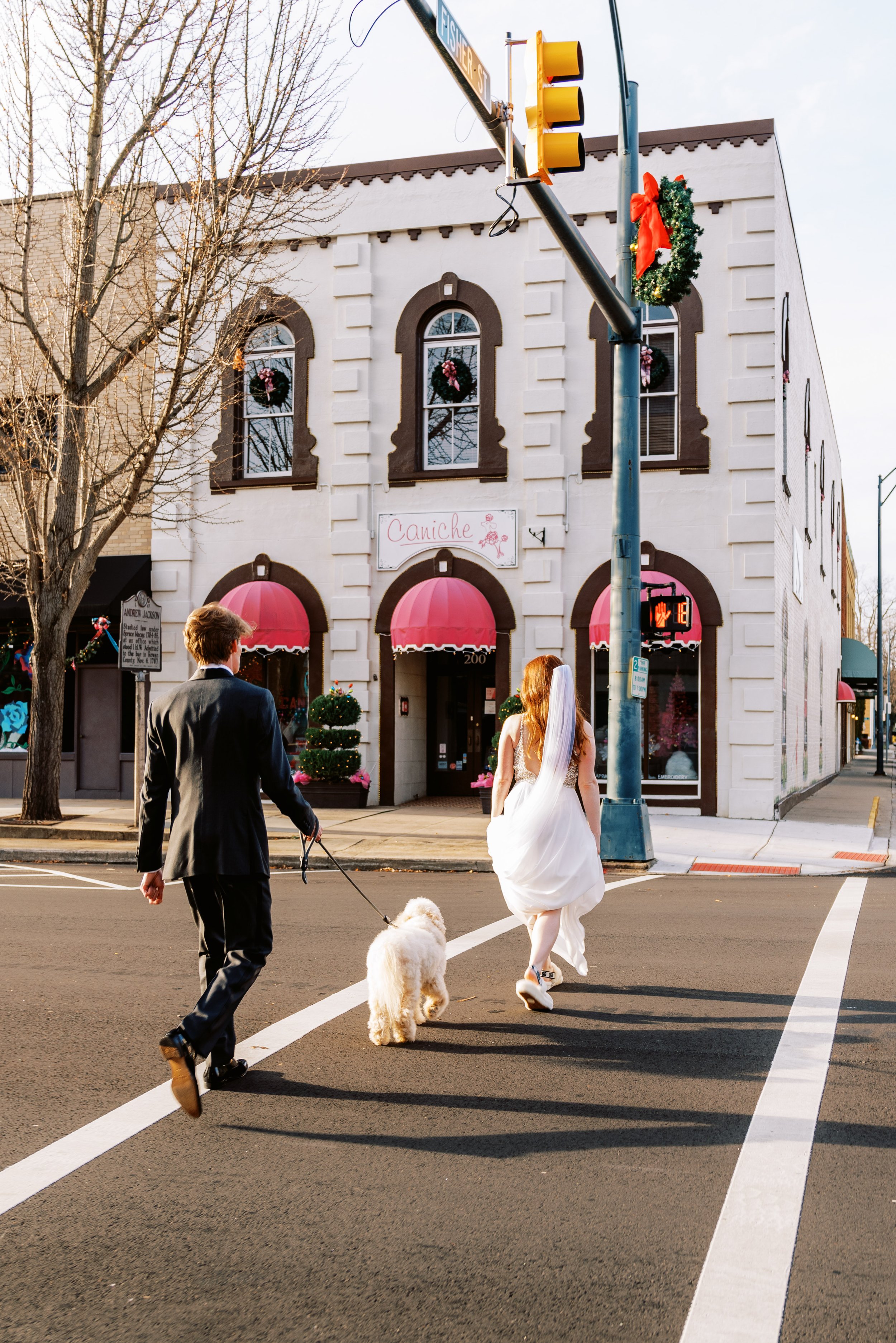 Bride and Groom Street Crossing Historic Downtown Salisbury North Carolina Wedding at The Meroney Theater  Fancy This Photography