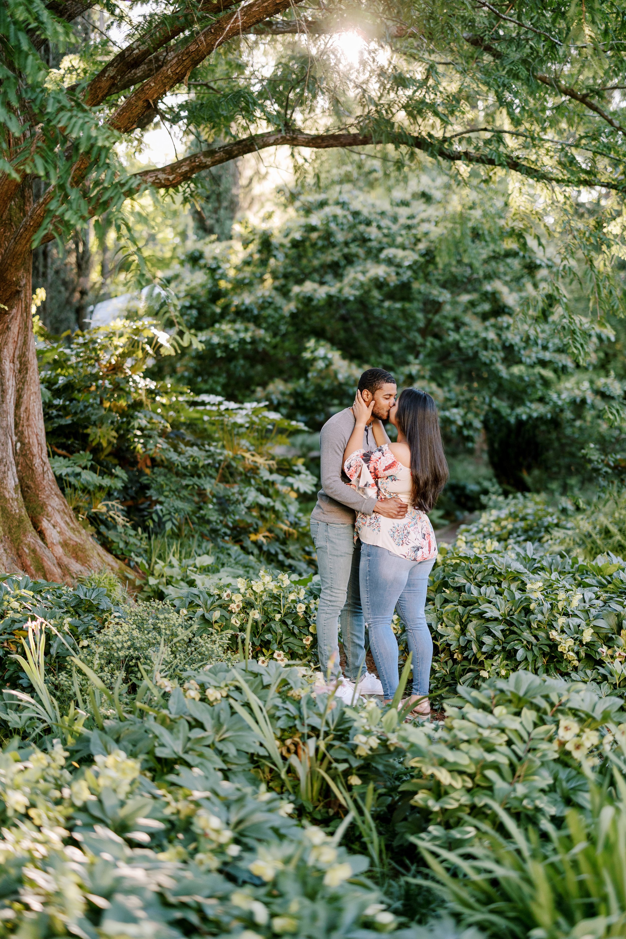 Couple in Green Forest Sunset Engagement Photos in The Raleigh Rose Garden Fancy This Photography