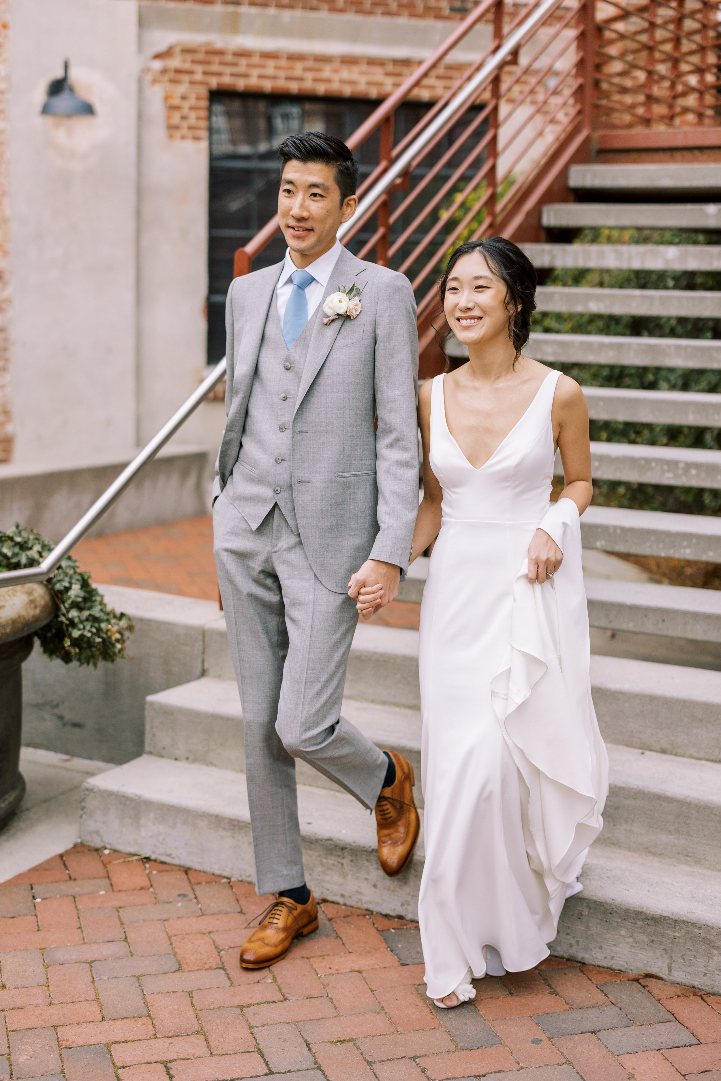 Bride and Groom Walk Down Staircase American Tobacco Campus Korean Wedding at Bay 7 Durham NC Fancy This Photography