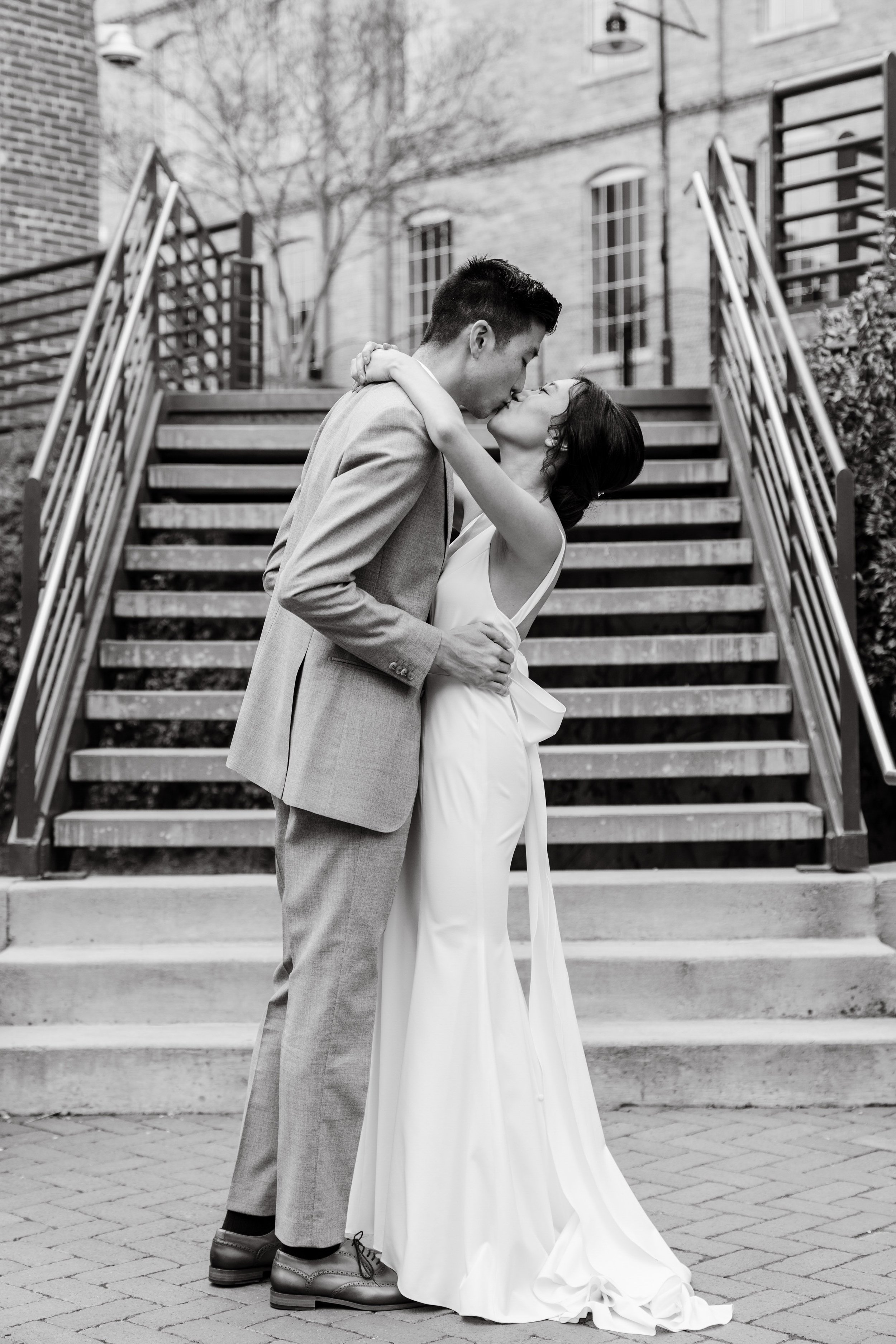 Bride and Groom Kiss Staircase American Tobacco Campus Korean Wedding at Bay 7 Durham NC Fancy This Photography