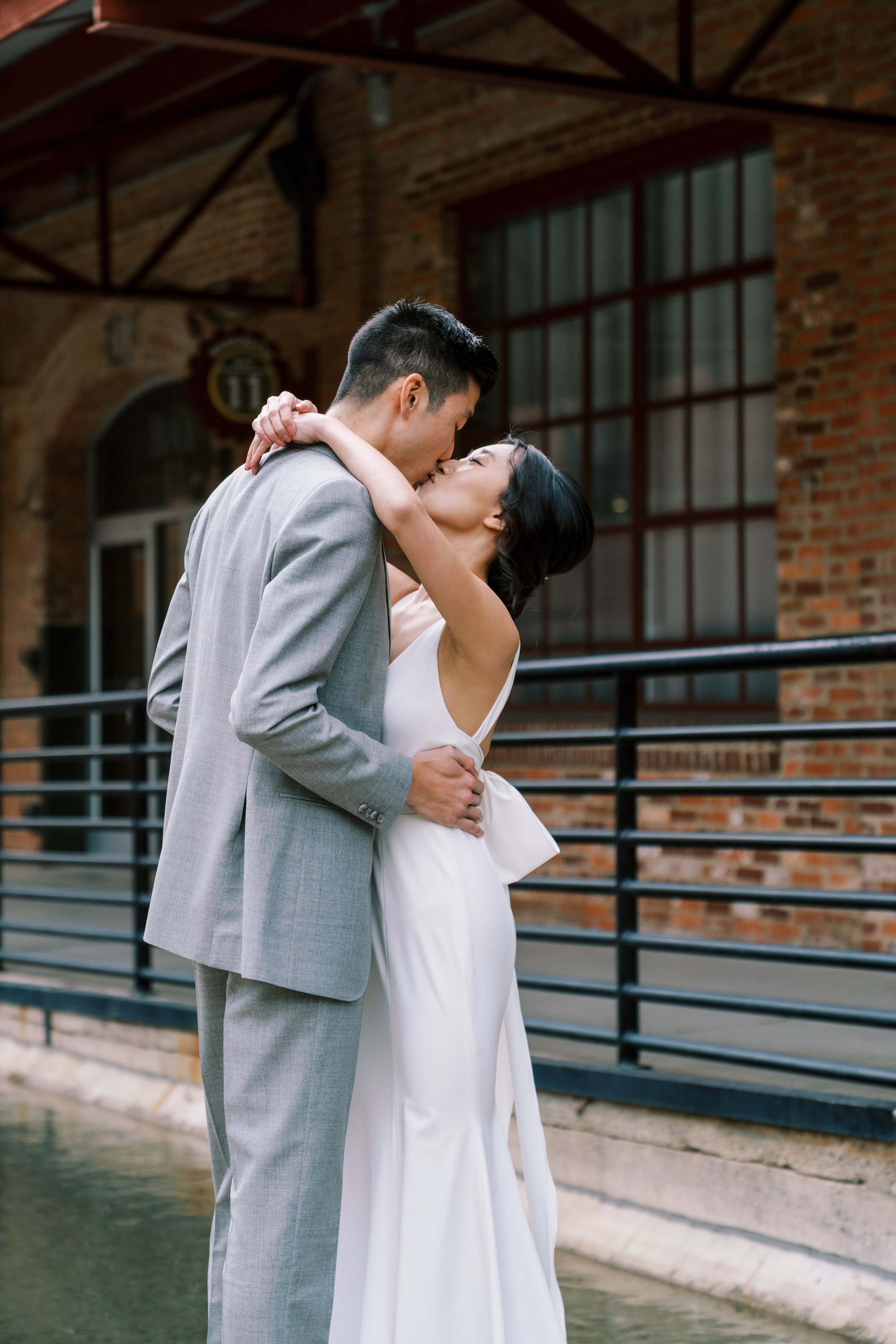 Bride and Groom Kiss Over Water American Tobacco Campus Wedding at Bay 7 Durham NC Fancy This Photography