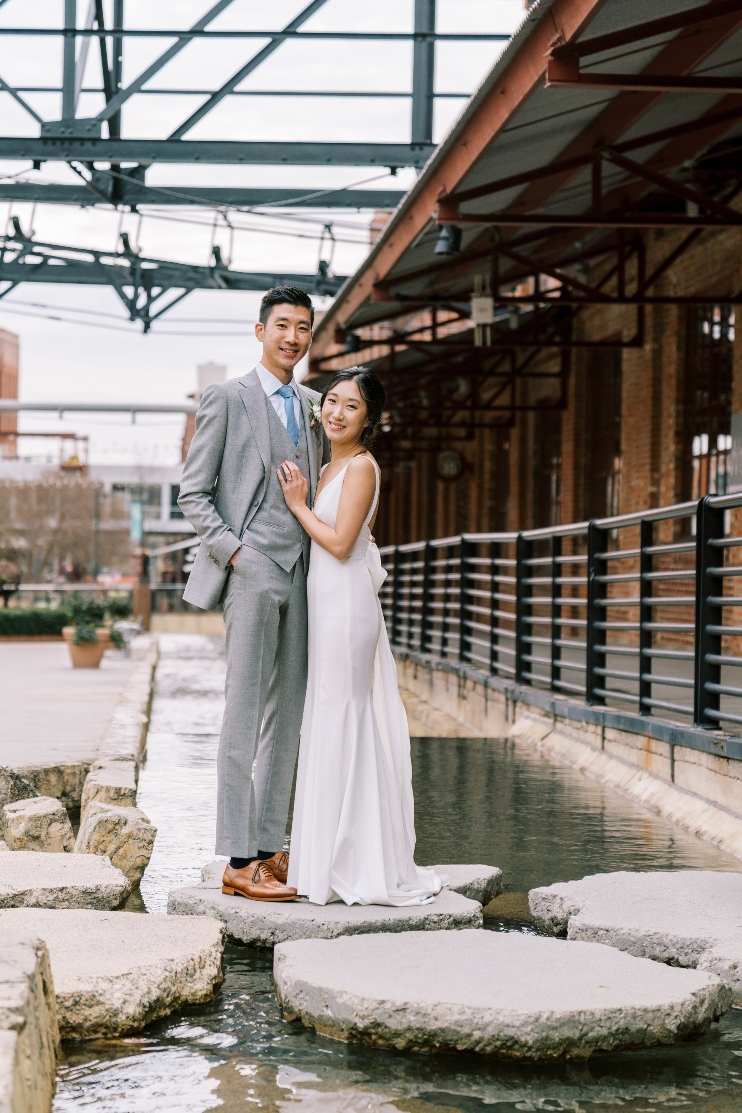 Bride and Groom Stand Over Water American Tobacco Campus Wedding at Bay 7 Durham NC Fancy This Photography