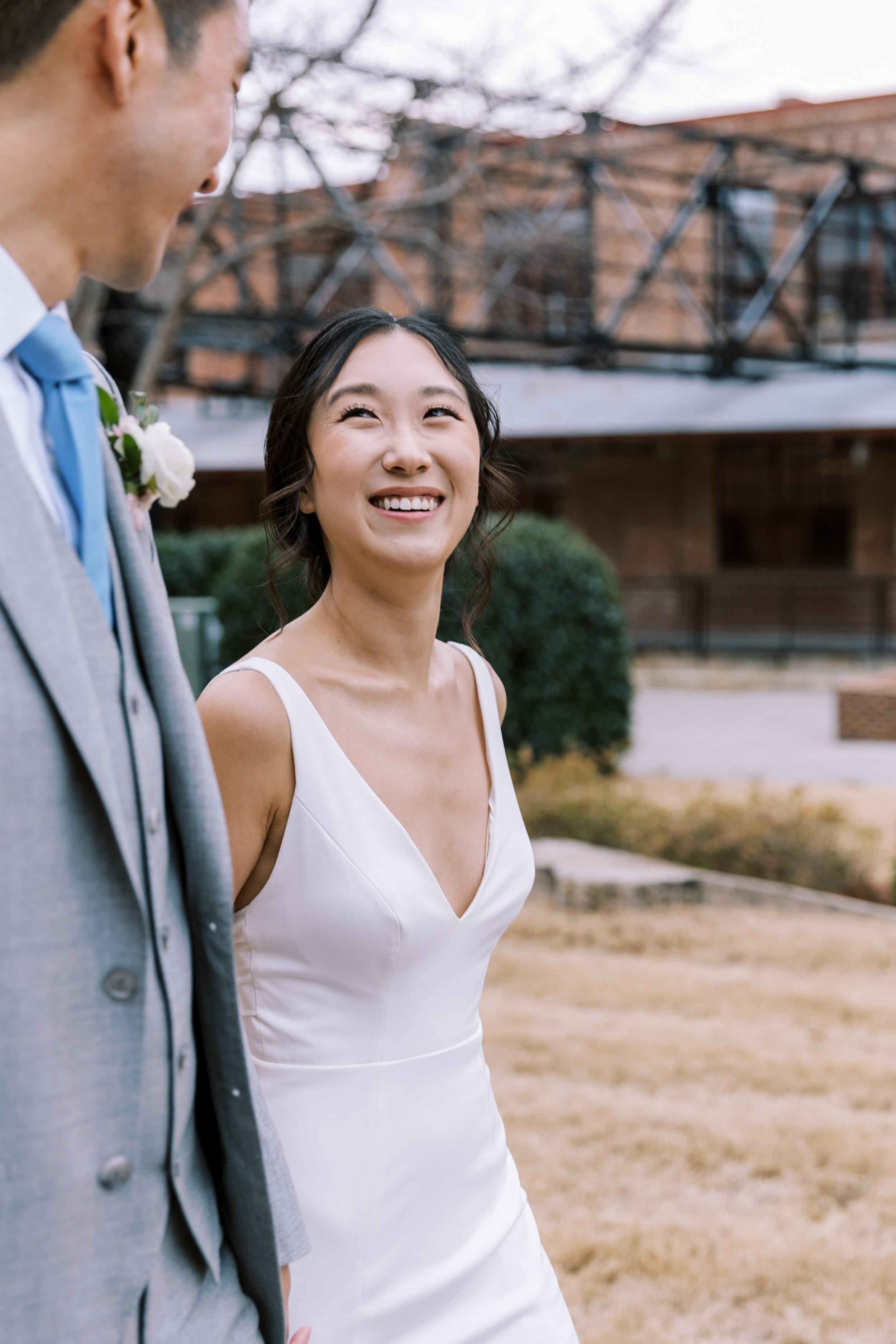 Bride Smiles at Groom in American Tobacco Campus Wedding at Bay 7 Durham NC Fancy This Photography
