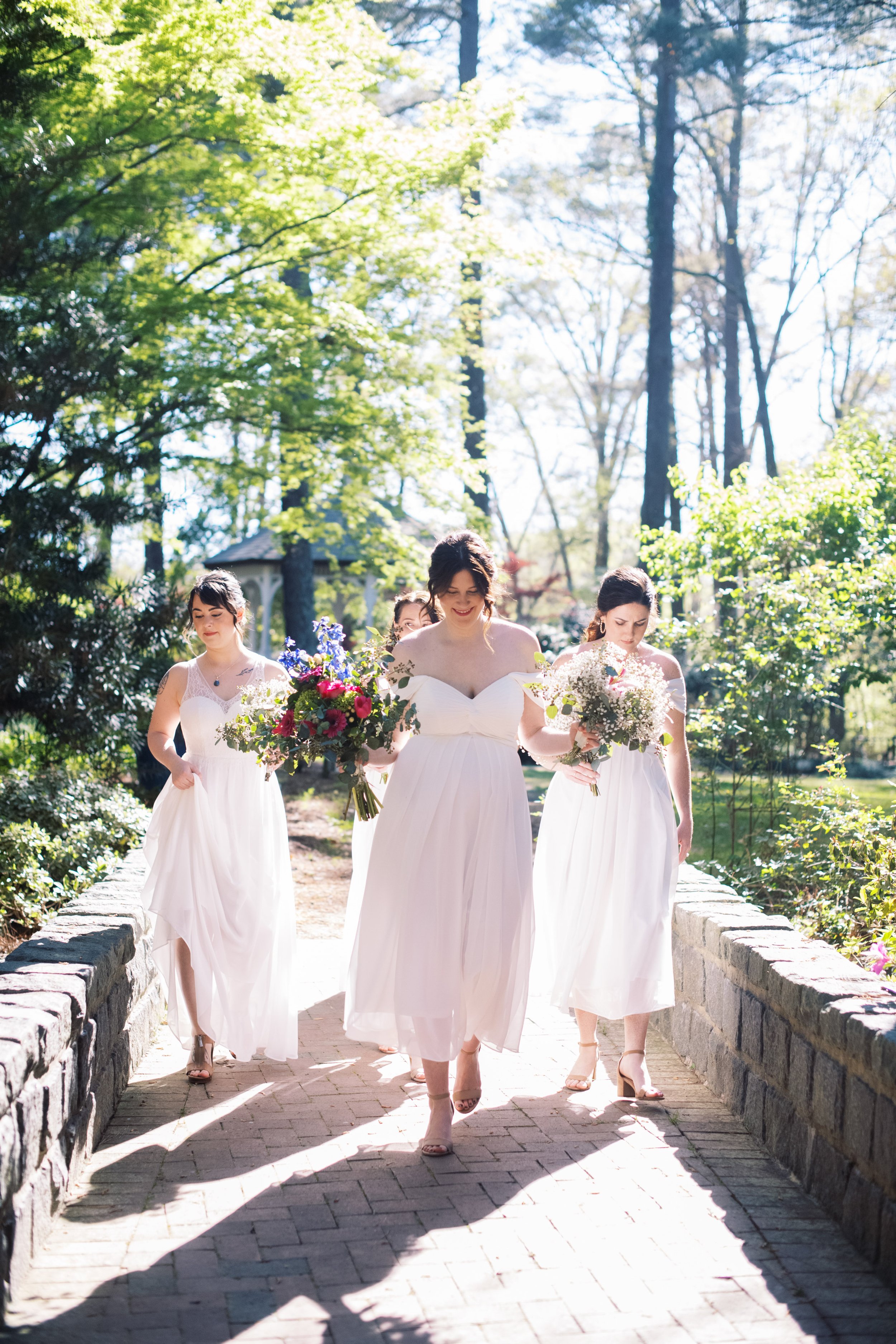 Bridesmaids in White Dresses Walking Through Cape Fear Botanical Garden Wedding Fancy This Photography