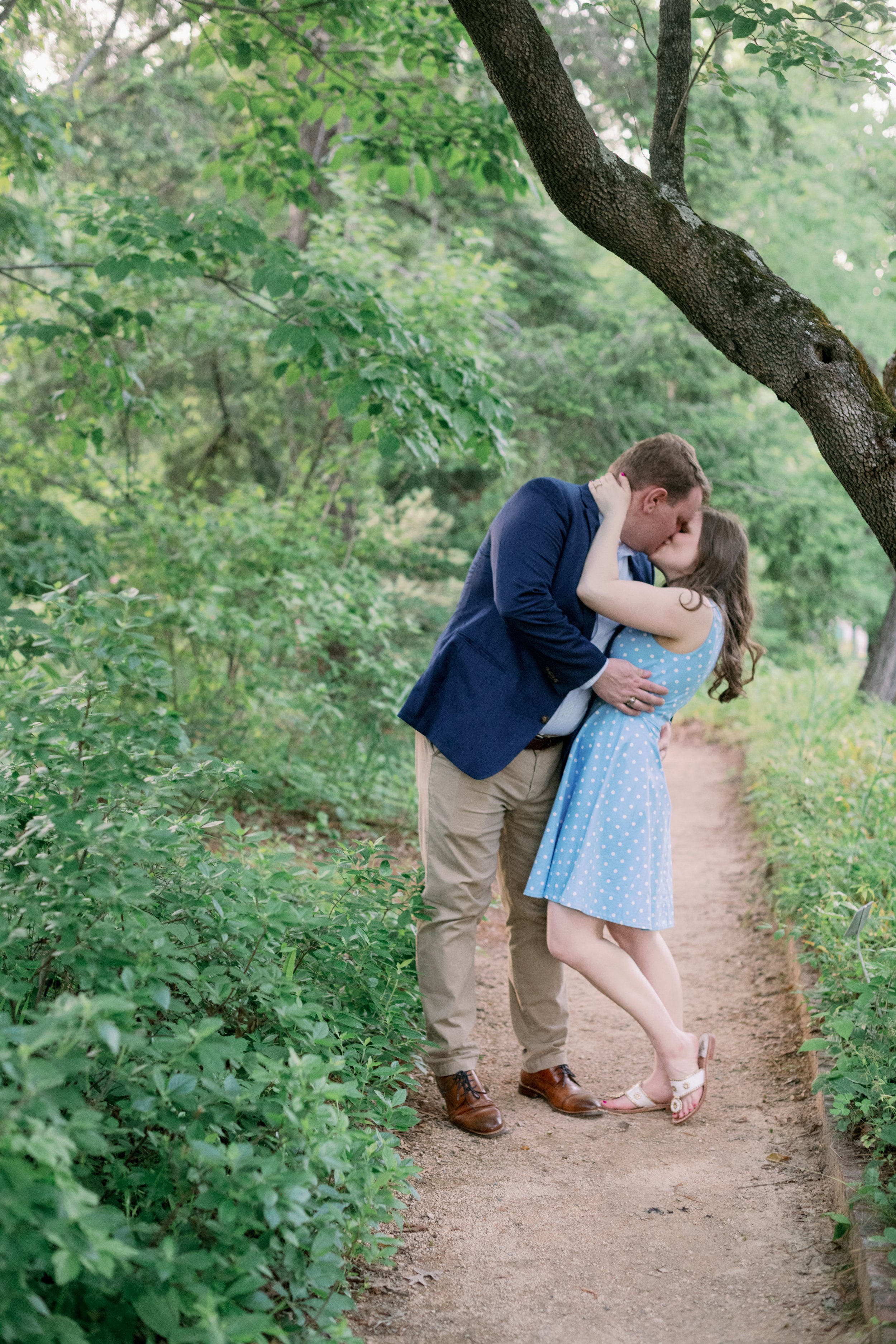 Coker Arboretum Couple Kiss on Pathway UNC Chapel Hill Engagement Photos Fancy This Photography