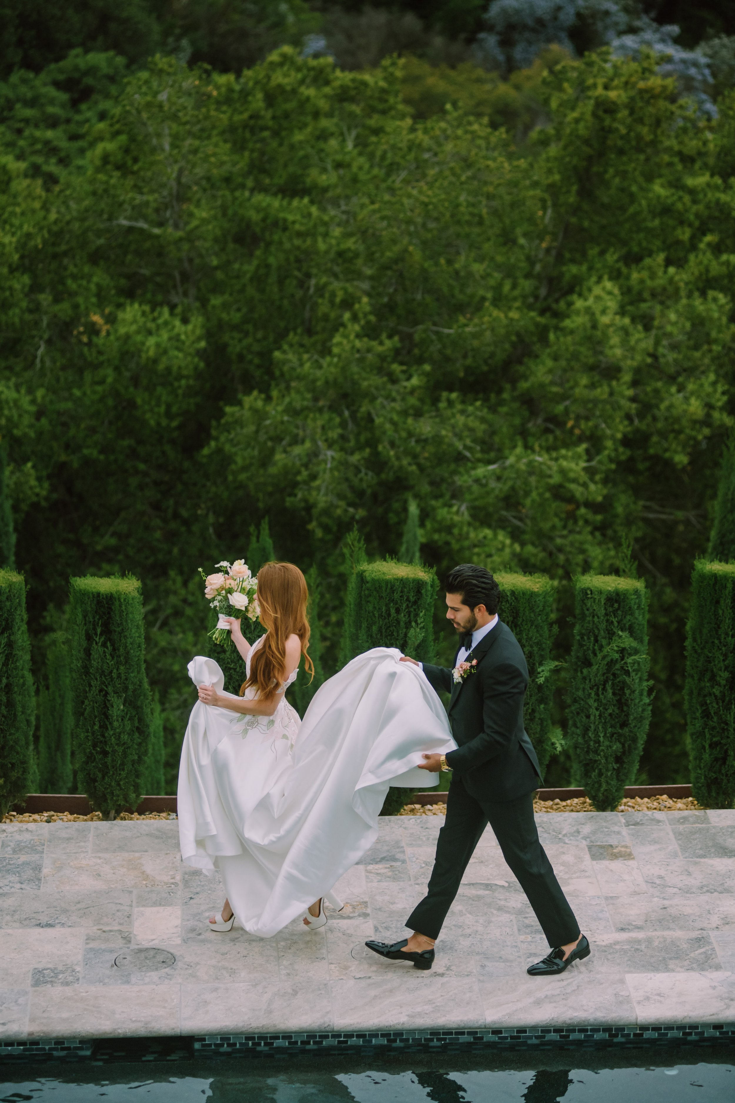 Bride and Groom Walk Poolside Stone Mountain Estates Wedding Venue Fancy This Photography