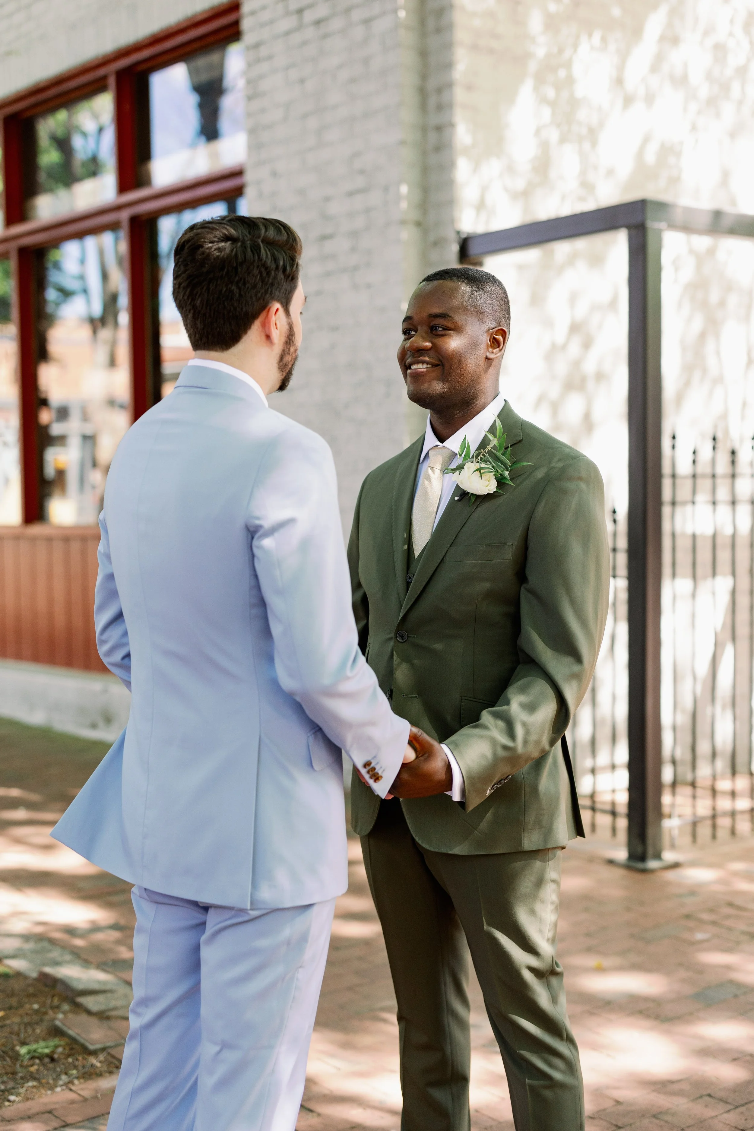 Grooms first look moment outside Market Hall in downtown Raleigh