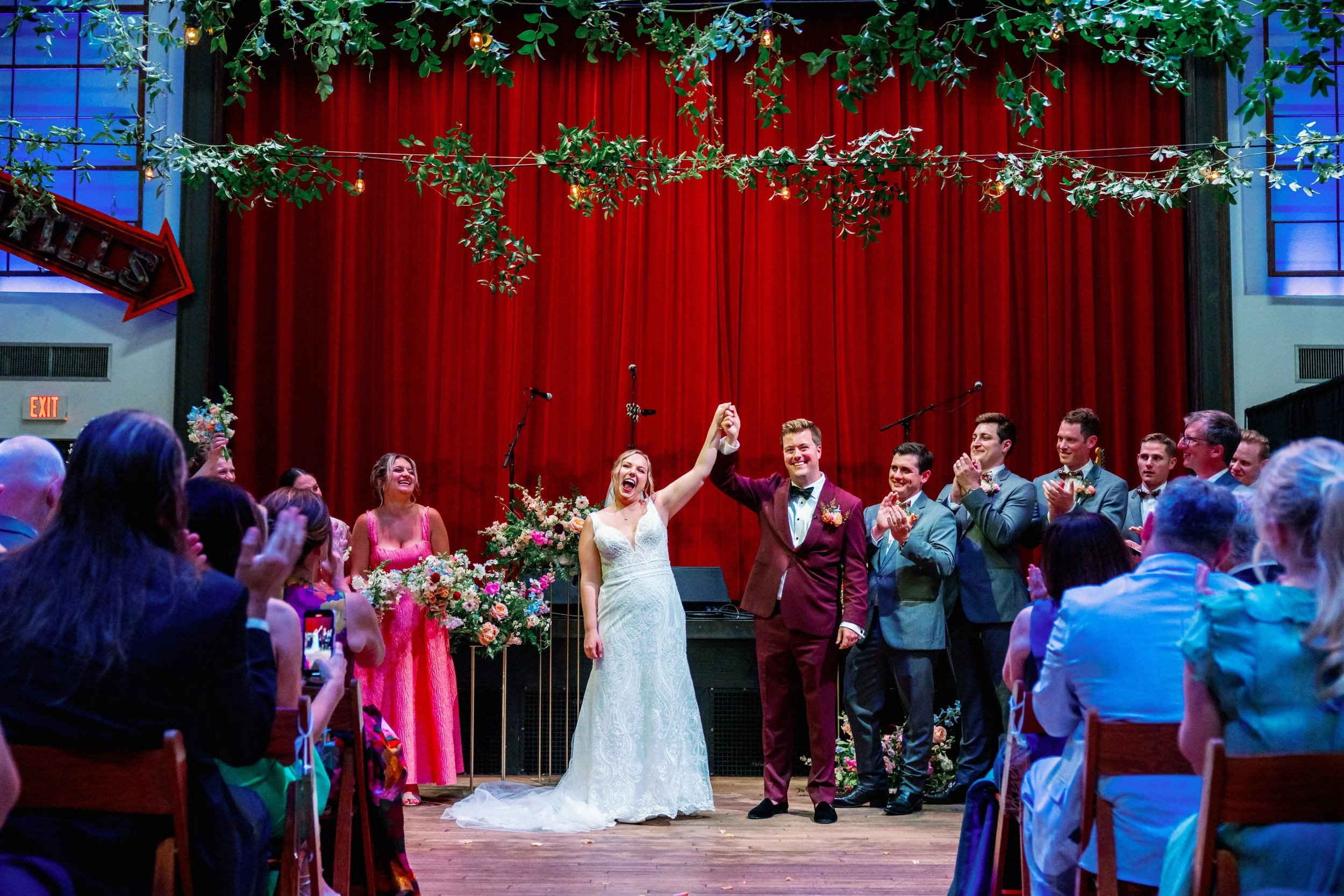  Bride and groom celebrating on stage at Haw River Ballroom in Saxapahaw North Carolina after their wedding ceremony 