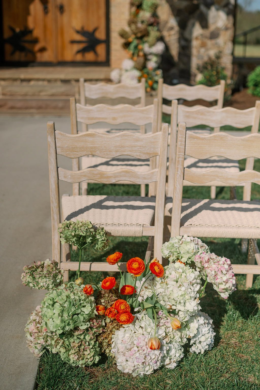  Hydrangea and ranunculus florals beside ceremony chairs at The Little Chapel at Haven Ridge, Winston-Salem 