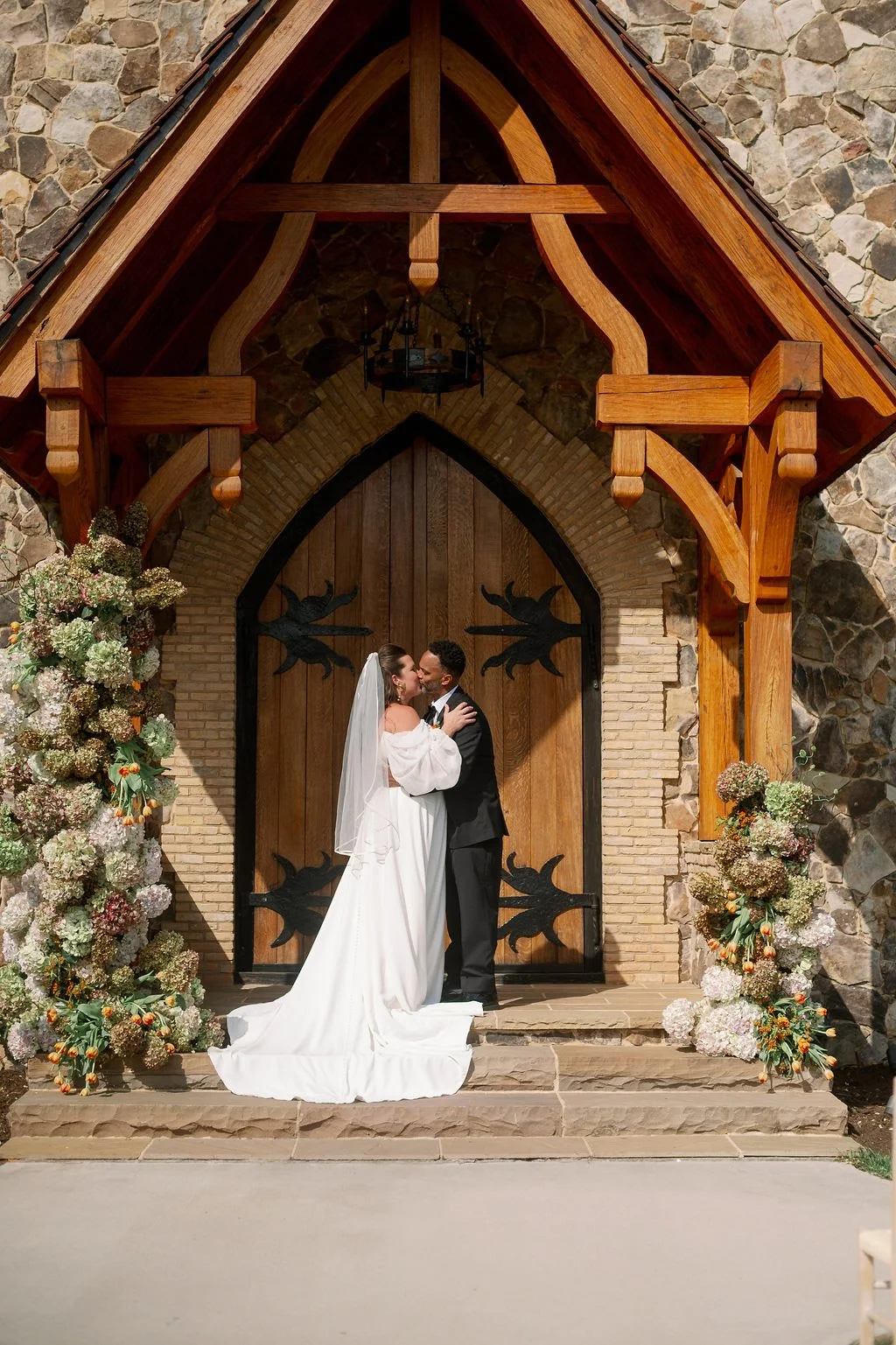  Couple kissing at the arched chapel doors of The Little Chapel at Haven Ridge in Winston-Salem NC 