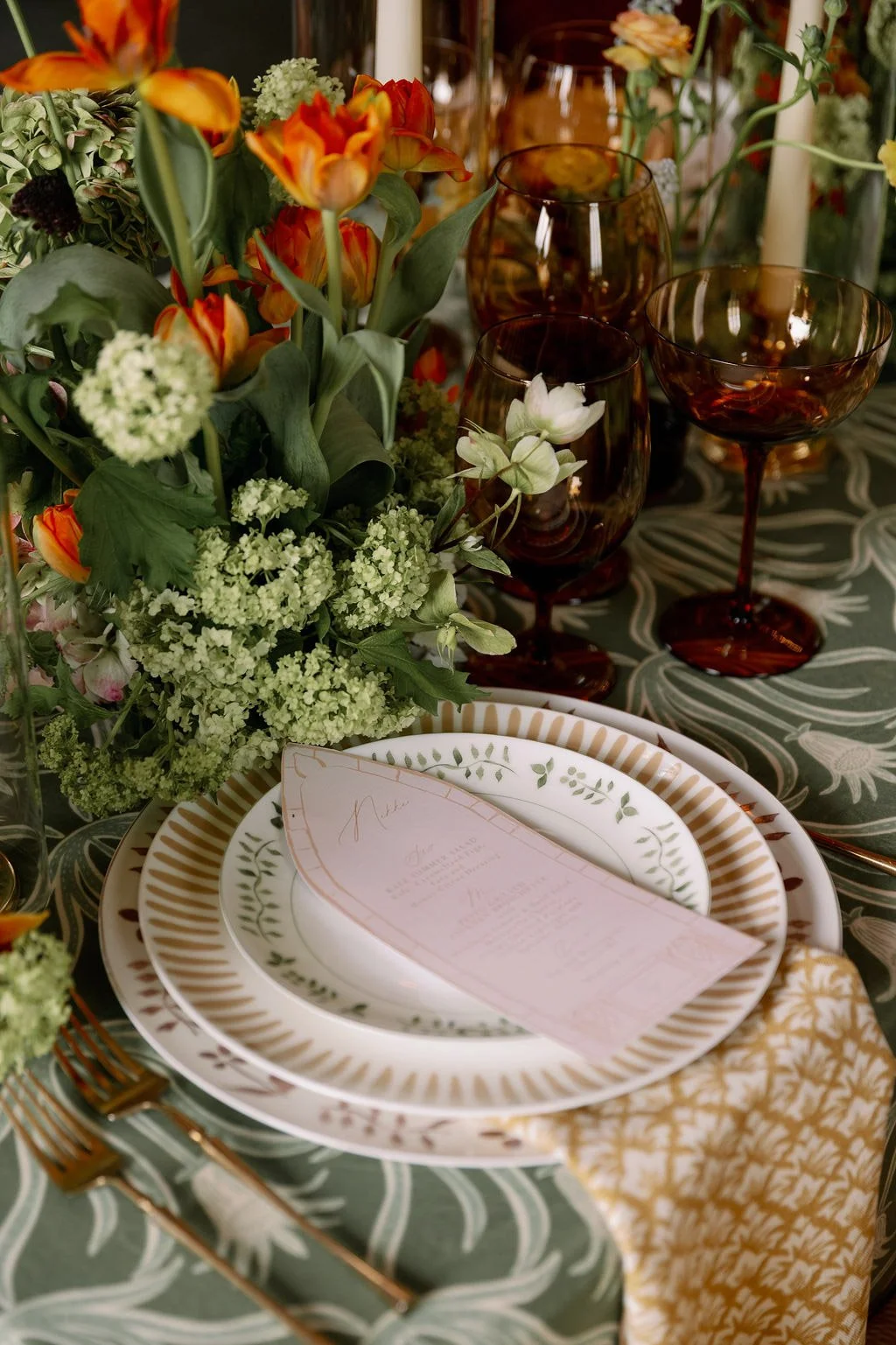  Place setting with patterned plates, menu, and spring florals at The Little Chapel at Haven Ridge 
