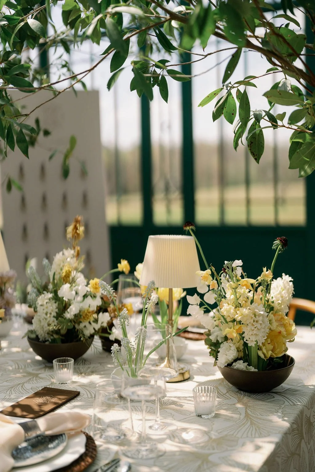  Spring centerpiece with daffodils and a pleated lamp in the Solarium at The Little Chapel at Haven Ridge 