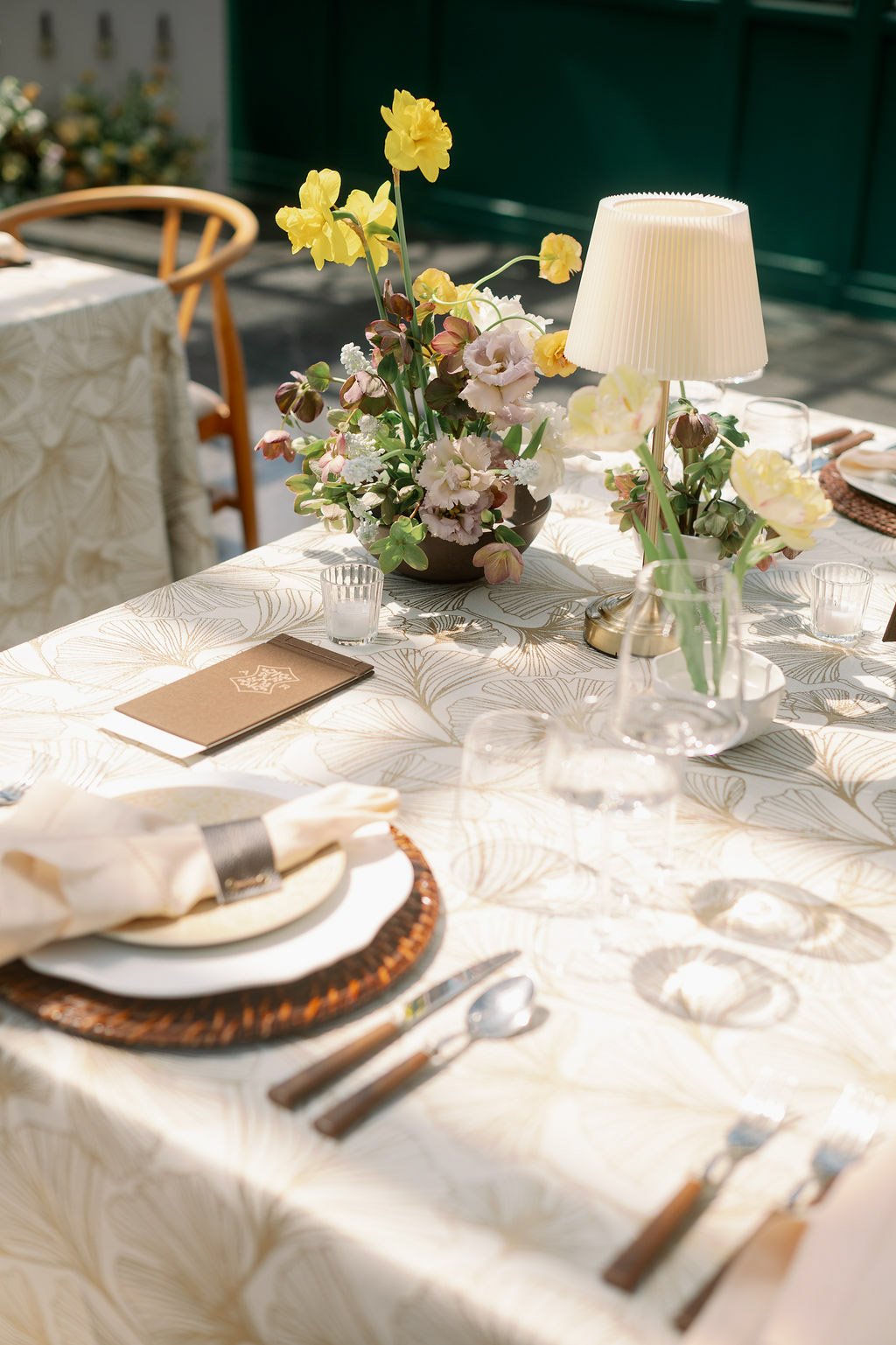  Place setting with woven charger and floral centerpiece in the Solarium at The Little Chapel at Haven Ridge 