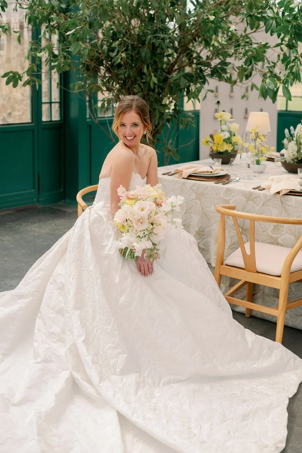  Bride with her bouquet seated at the reception table in the Solarium at The Little Chapel at Haven Ridge 