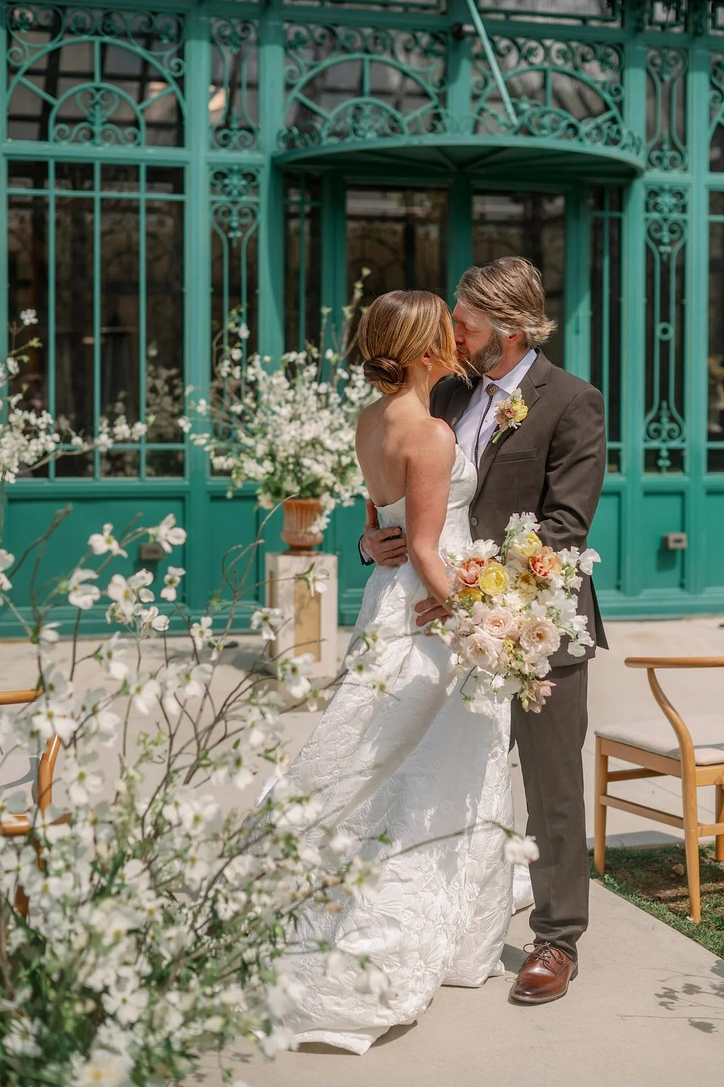  Couple kissing outside the Solarium with spring florals at The Little Chapel at Haven Ridge 