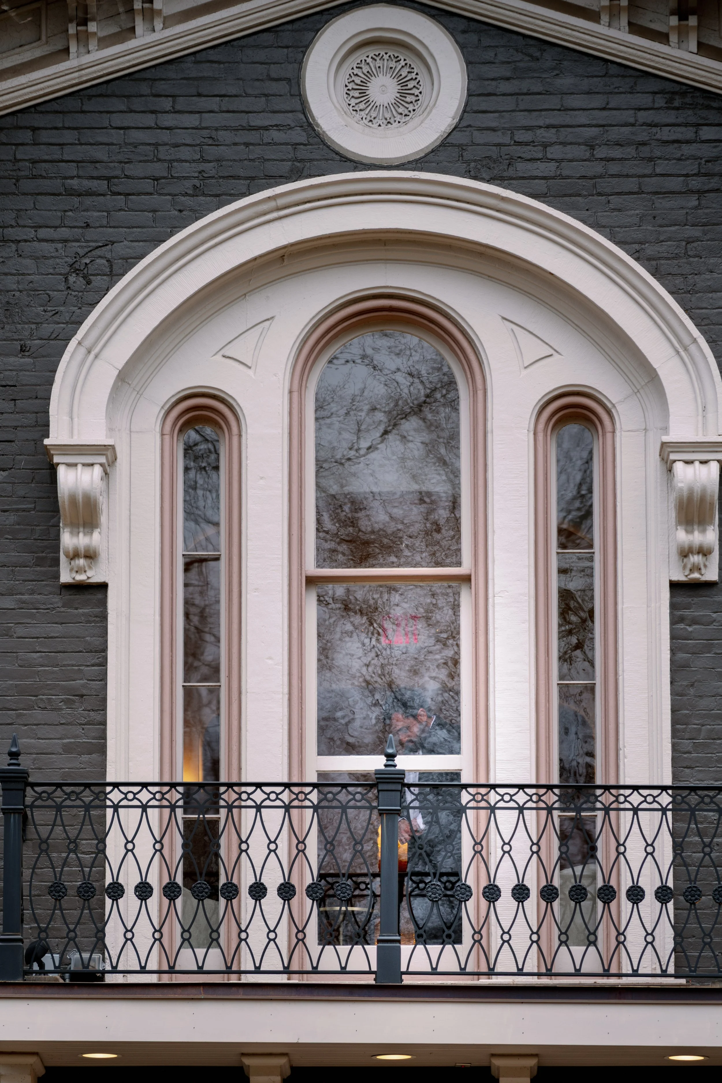  Arched balcony window with wrought iron railing on the historic facade of Heights House Hotel in Raleigh 