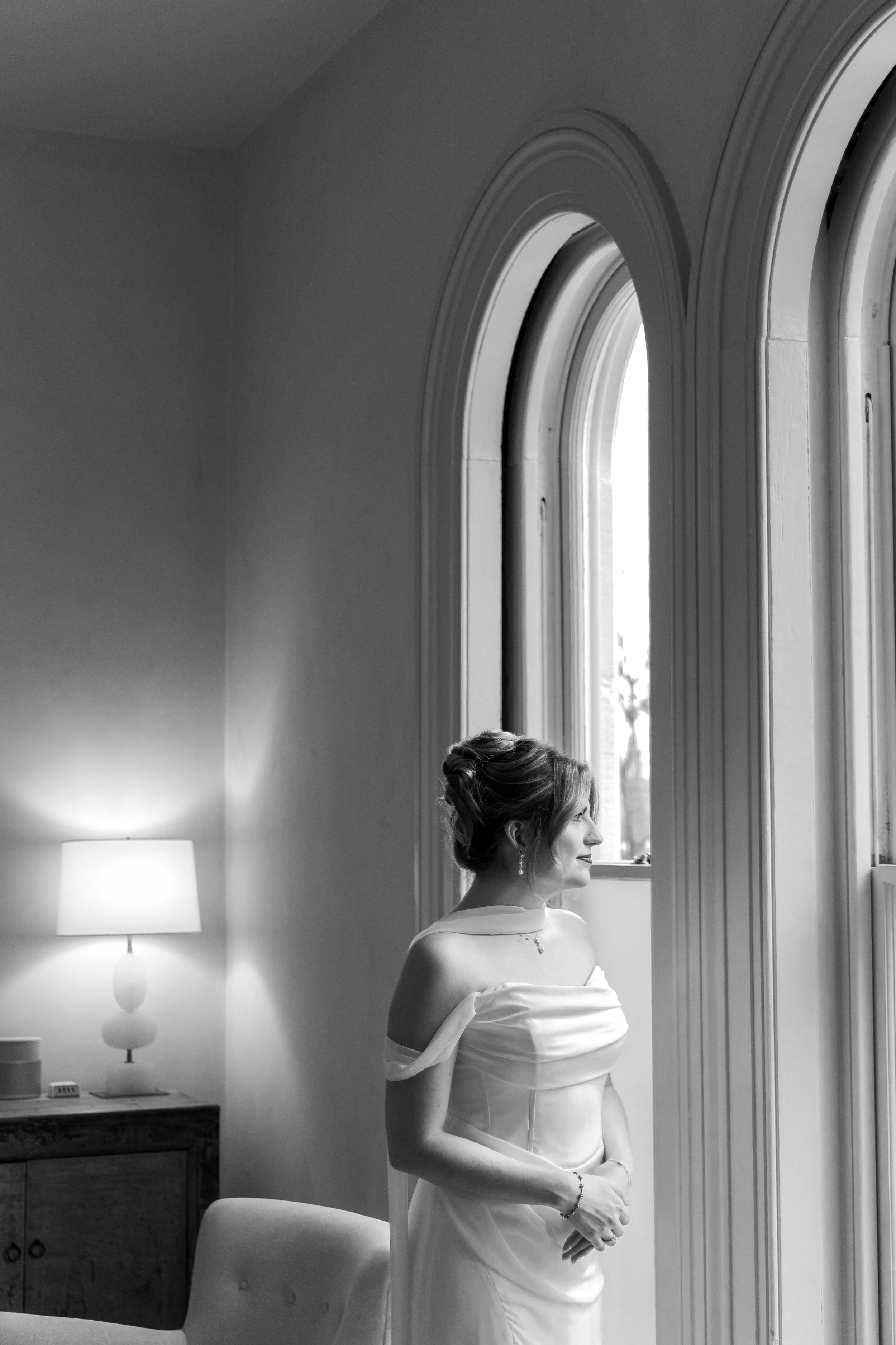  Bride looking out an arched window in the getting ready suite at Heights House Hotel 