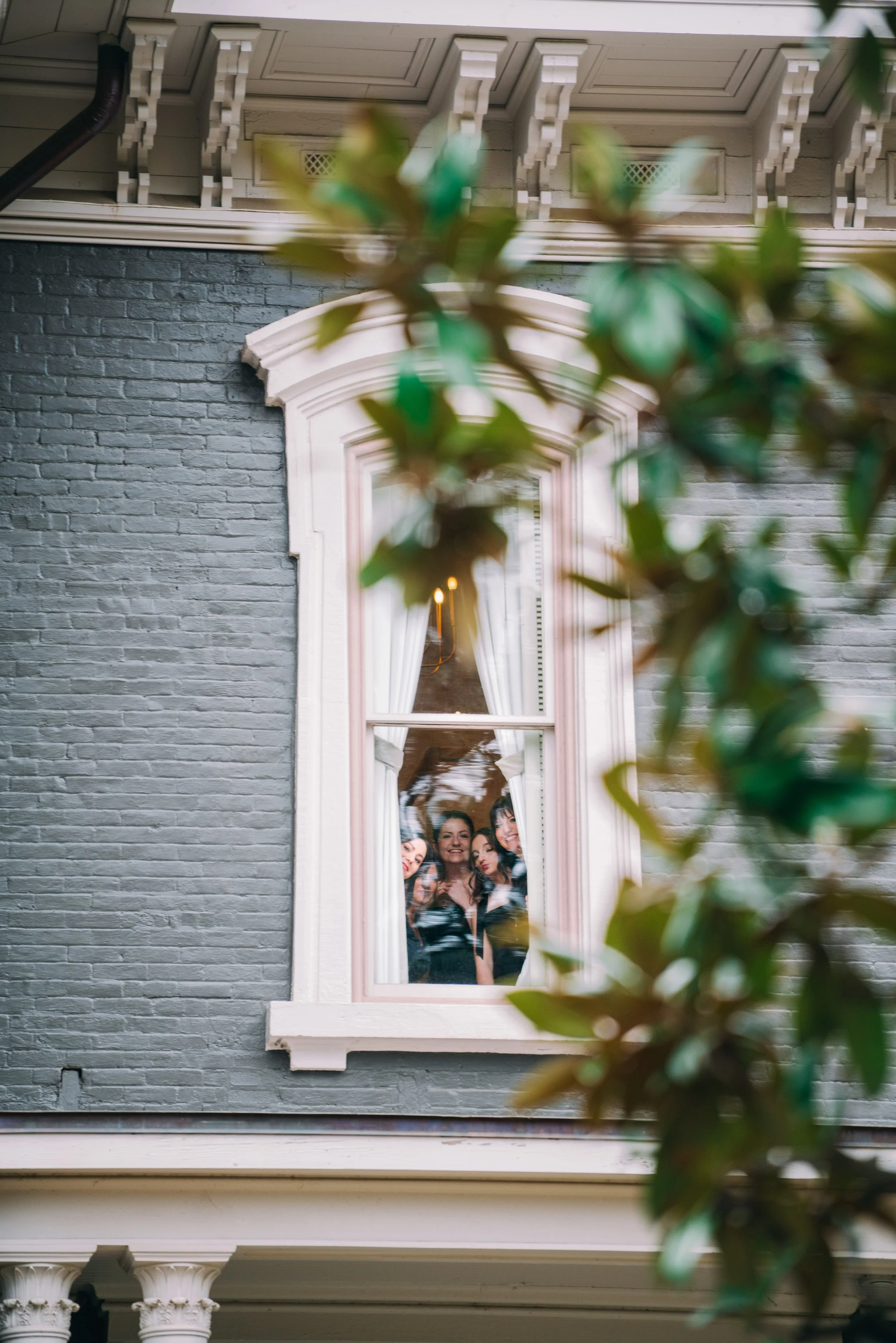  Wedding guests peeking through an arched window at Heights House Hotel in downtown Raleigh 