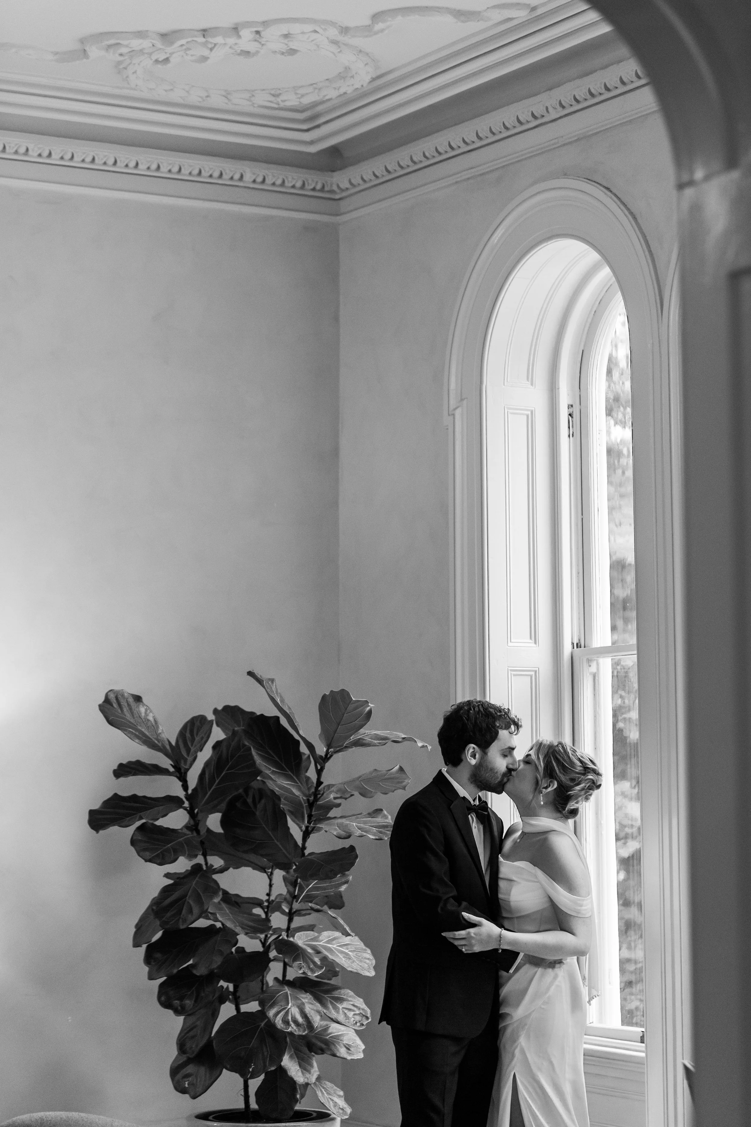  Bride and groom share an intimate moment near a fiddle leaf fig in the Heights House getting ready lounge 