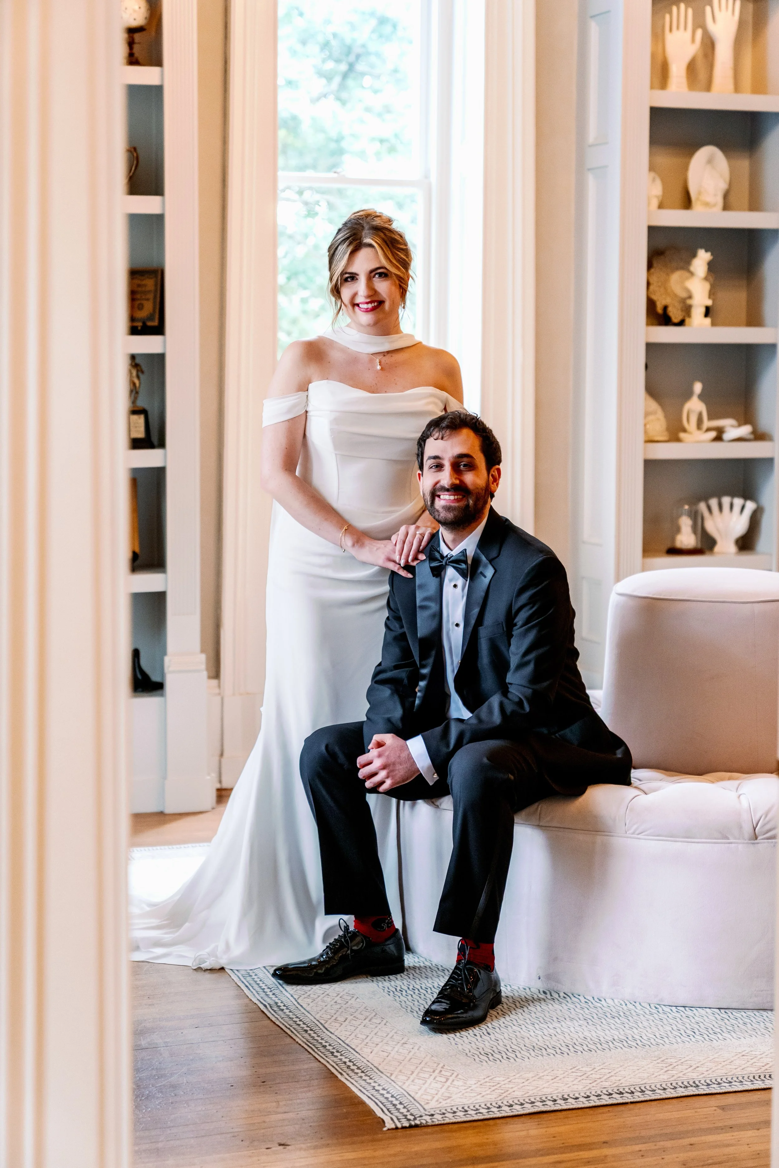  Bride and groom pose in the Heights House library surrounded by built-in shelving and natural light 