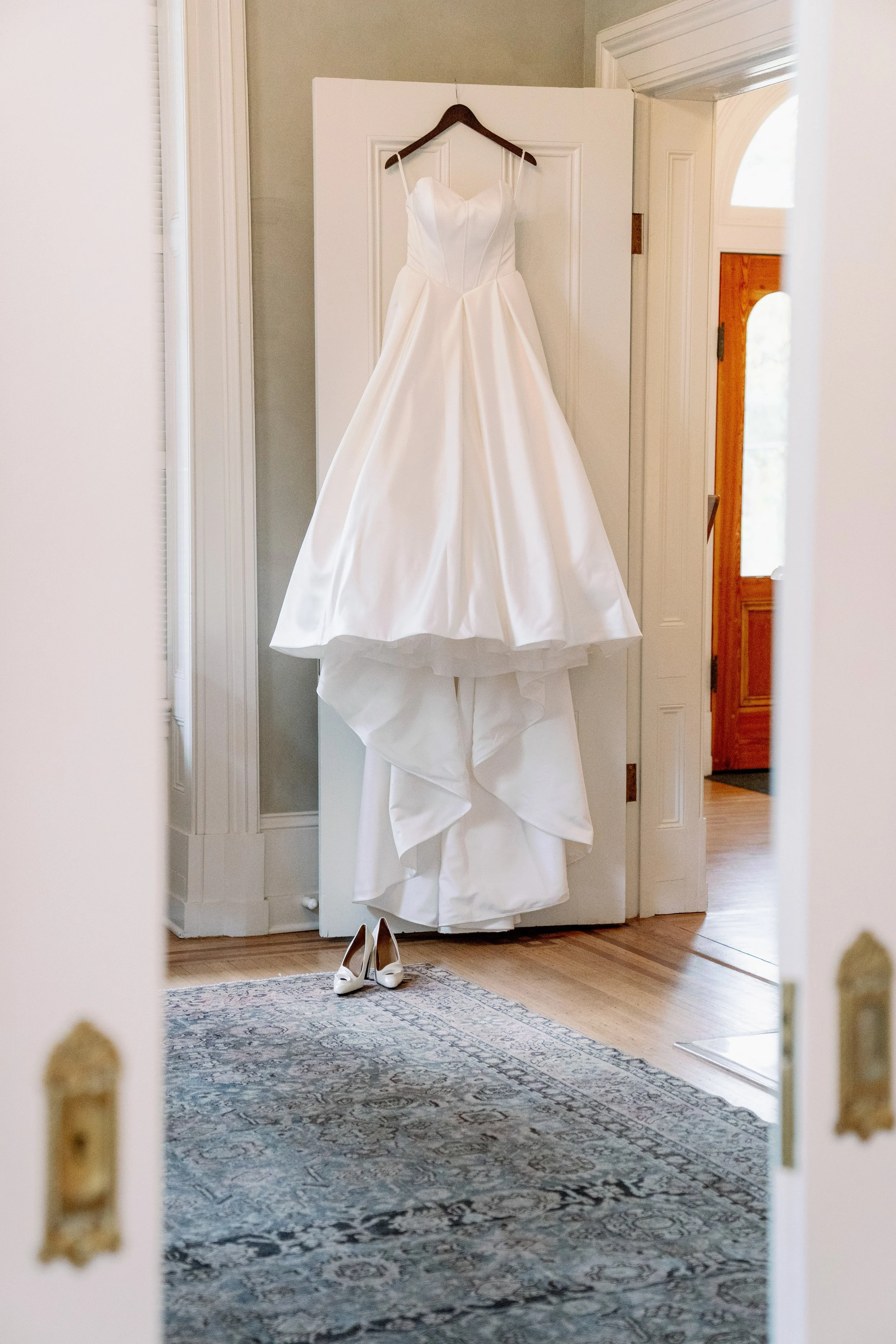  Wedding dress hanging in a doorway of the getting ready suite at Heights House Hotel in Raleigh 