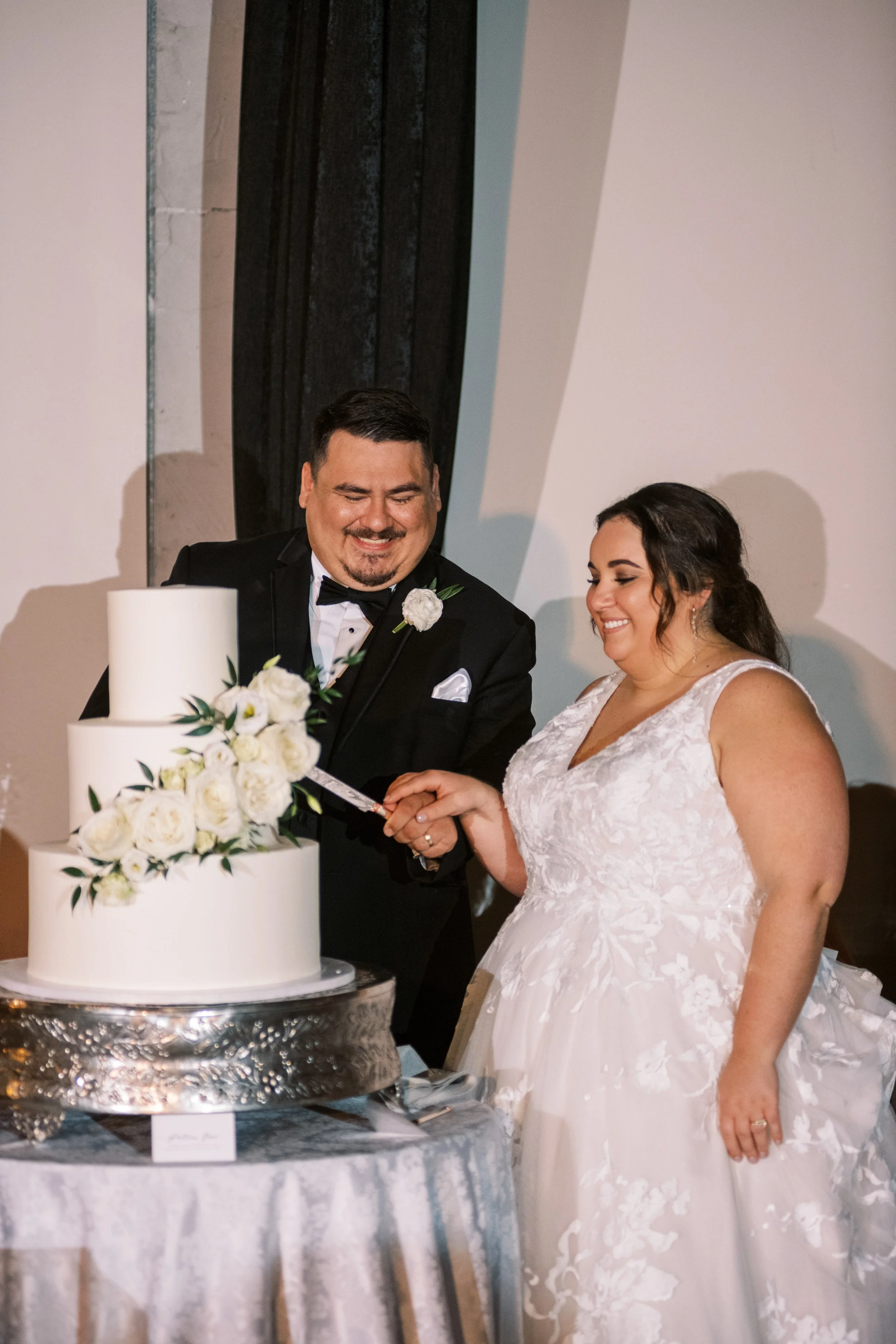 Couple cutting their wedding cake at Whitaker and Atlantic in Raleigh, surrounded by modern industrial details.