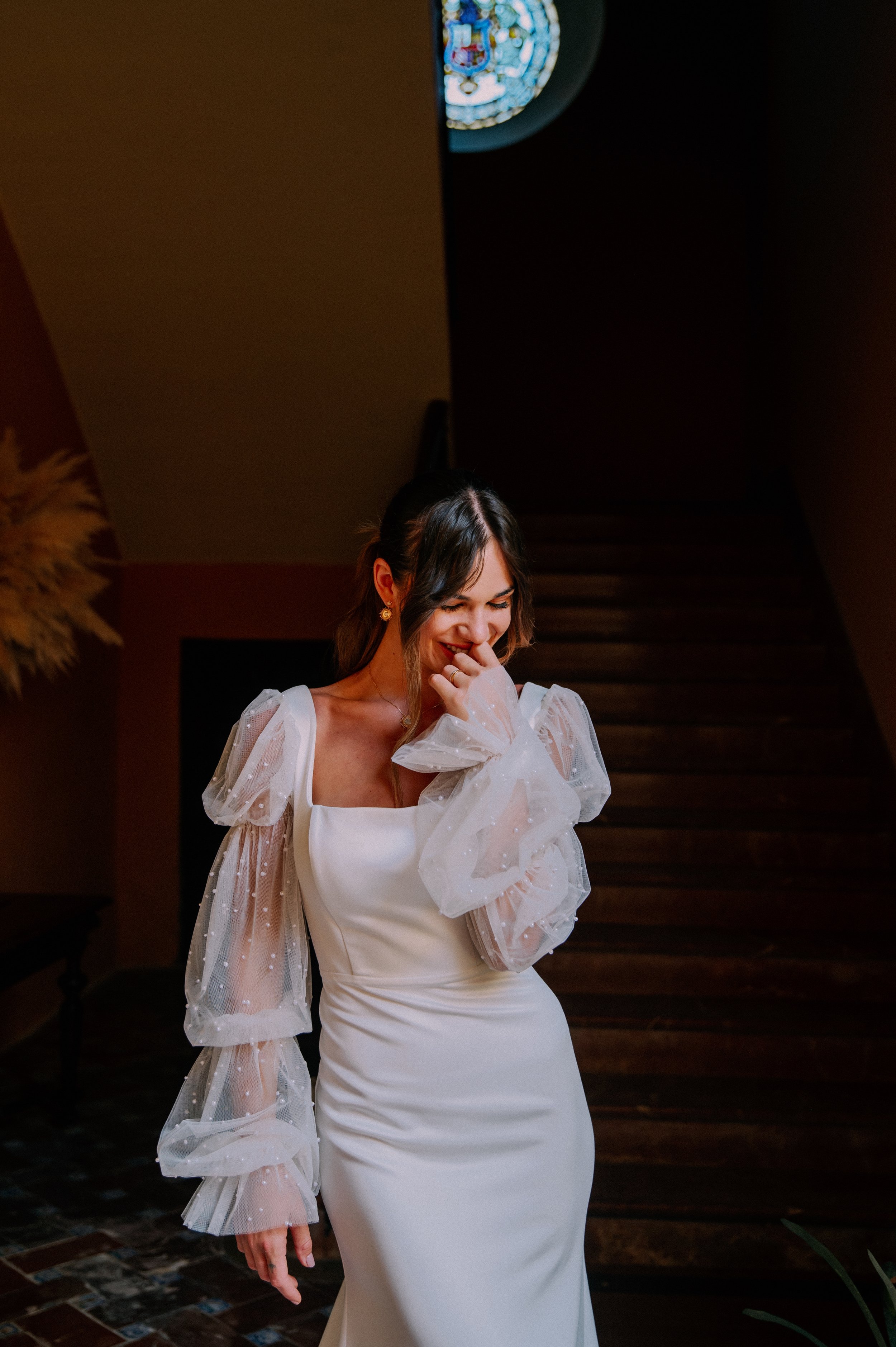 An editorial bridal portrait taken inside a historic building in Seville. Soft window light and dramatic shadows create a timeless, cinematic feel that reflects the romance of southern Spain.