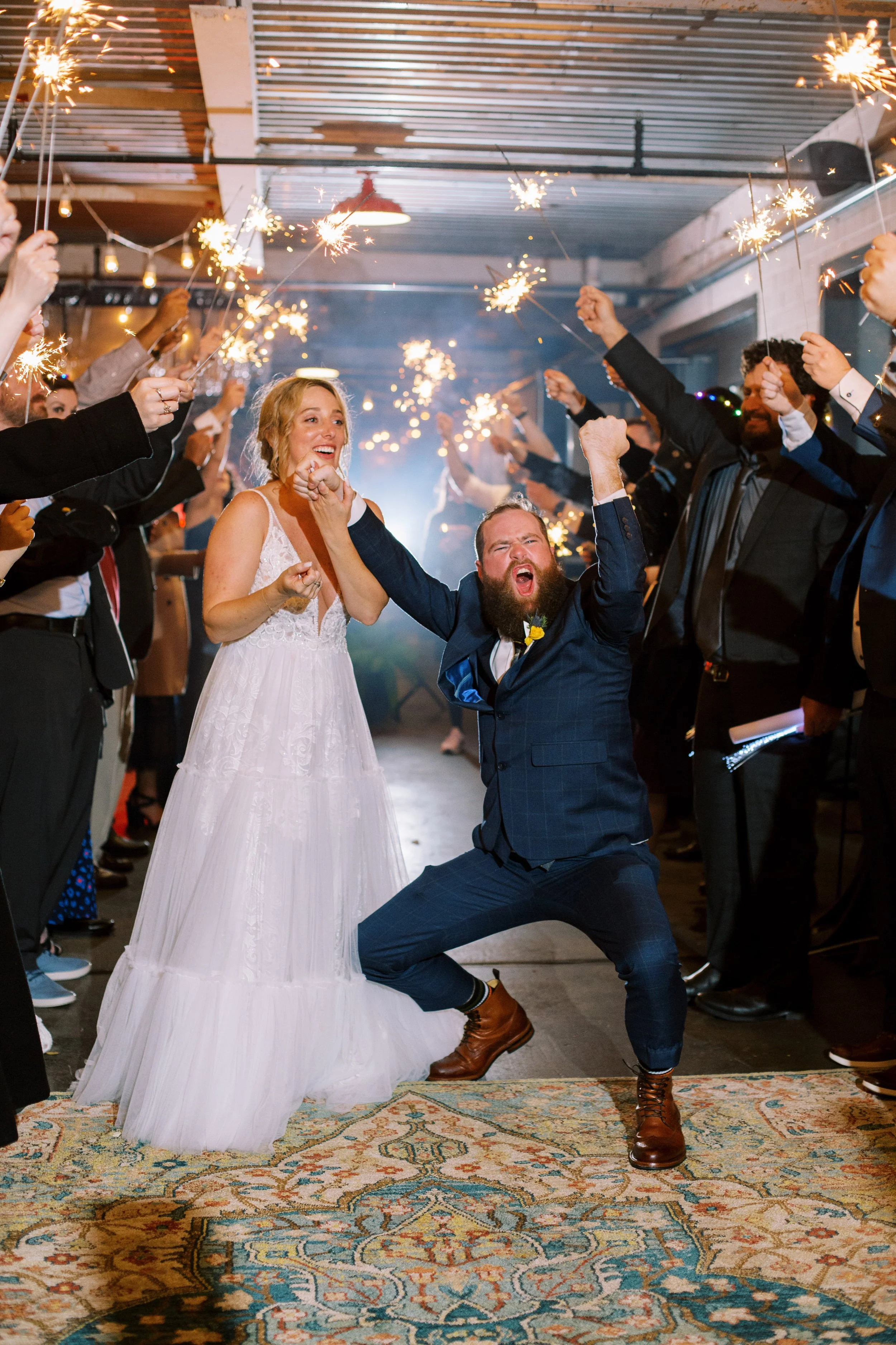 An electric sparkler exit at a Whitaker and Atlantic wedding, with the bride and groom celebrating in the center of the crowd as guests cheer them on, capturing the joy, energy, and party-forward spirit of the night.