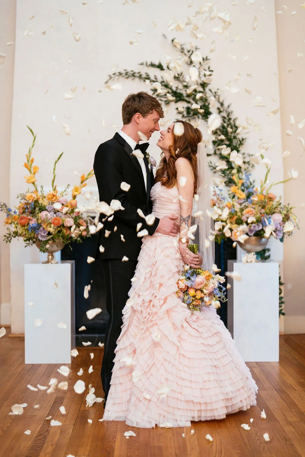 Bride in pink ruffled wedding gown and groom during petal toss ceremony at North Carolina wedding venue