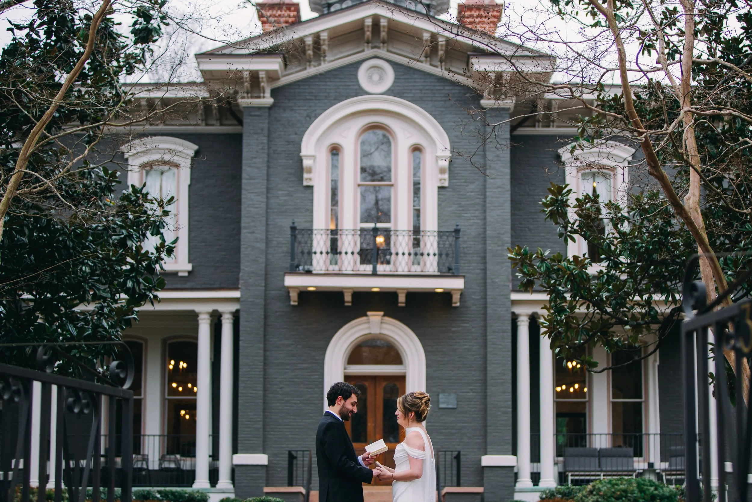 Bride and groom exchange vows during a private vow reading in front of the Heights House Hotel facade in downtown Raleigh