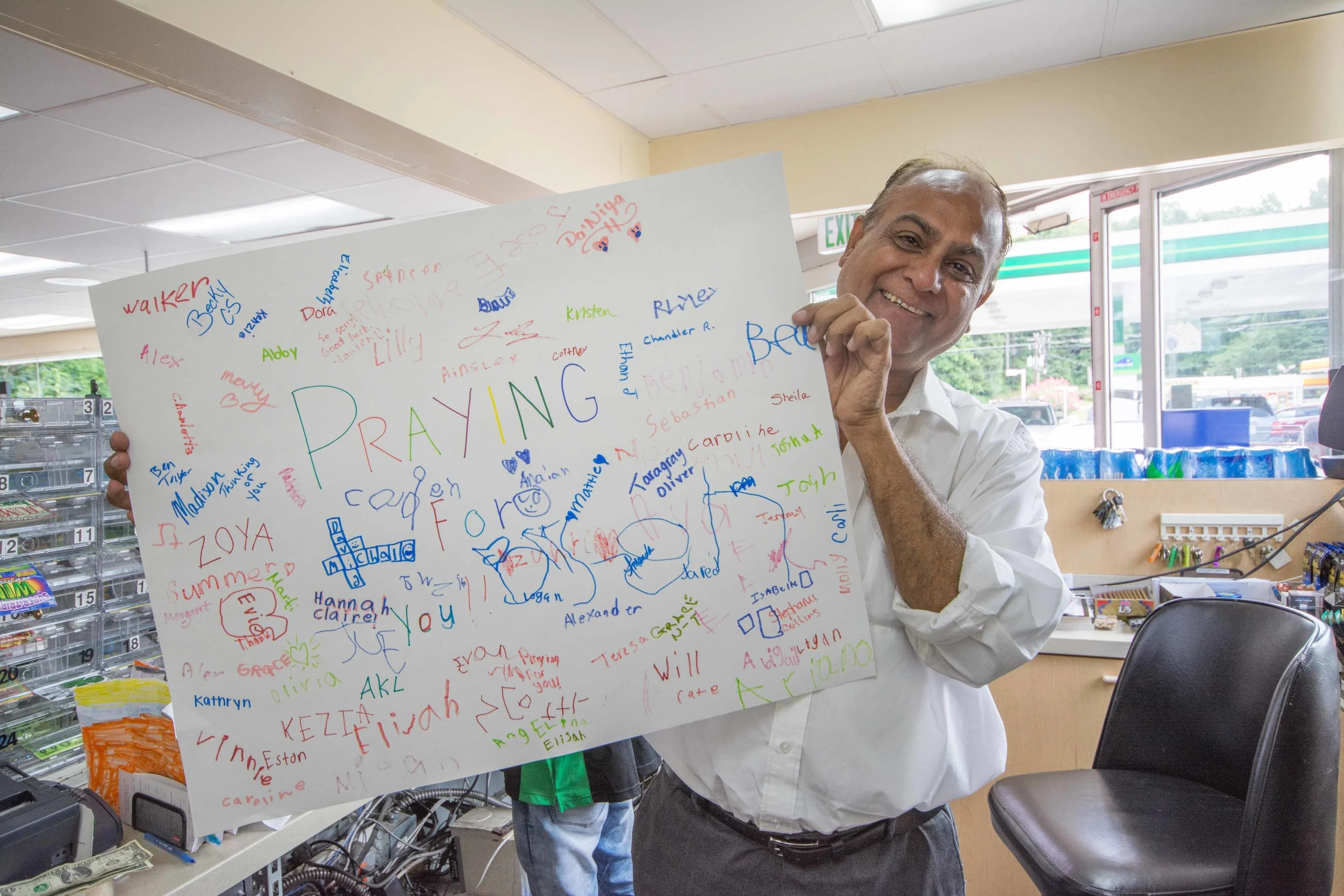 Store owner Bahadurali Waliyani with a card made by Smoke Rise Vacation Bible School children.