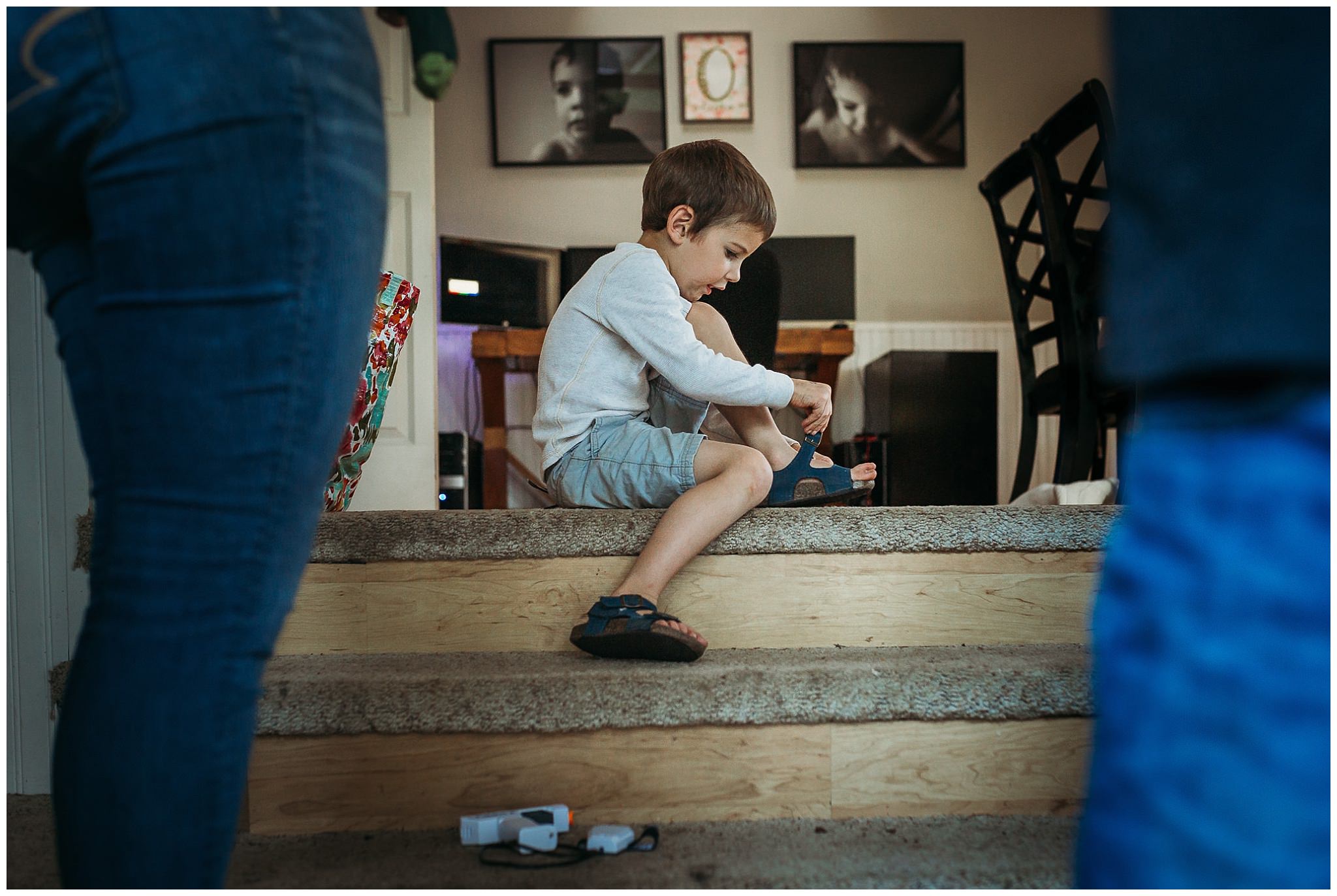 boy putting on shoes at door step