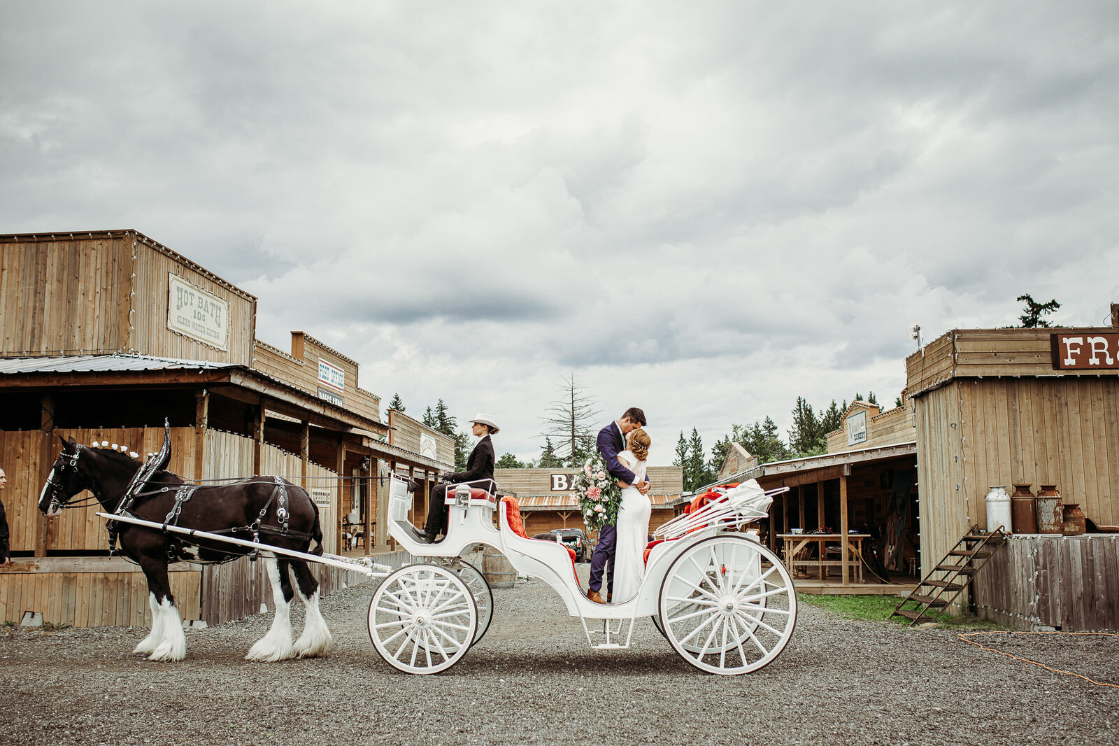  Bride and Groom kissing in horse drawn carriage outside the ceremony site at the Loft Country in Langley, BC.  