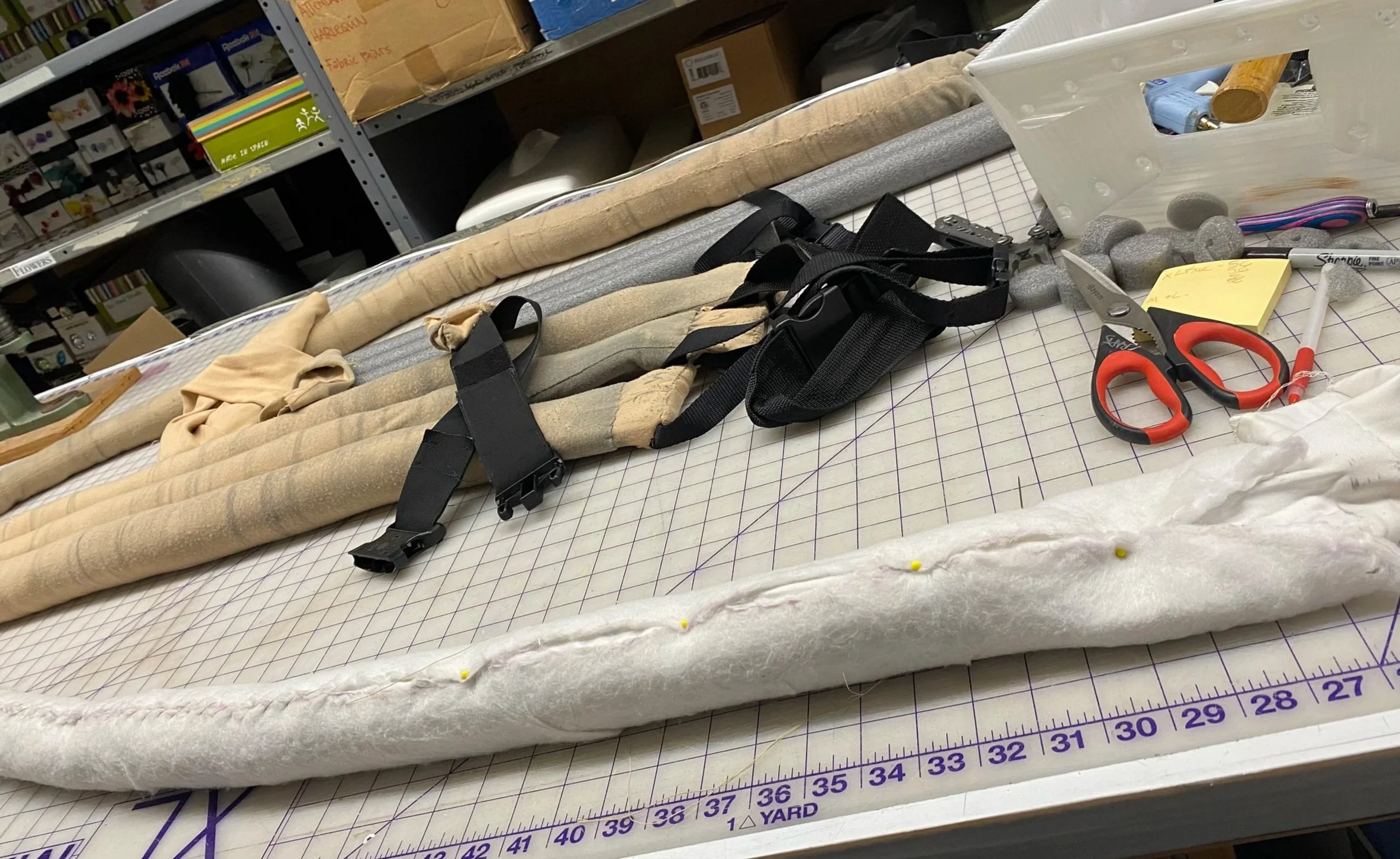  This image shows the rebuilt mouse tail structure wrapped in batting to create a smooth transition between the articulated interior and the outer “skin,” ensuring a clean silhouette.  Behind this, you can see the re-assembled tails. 