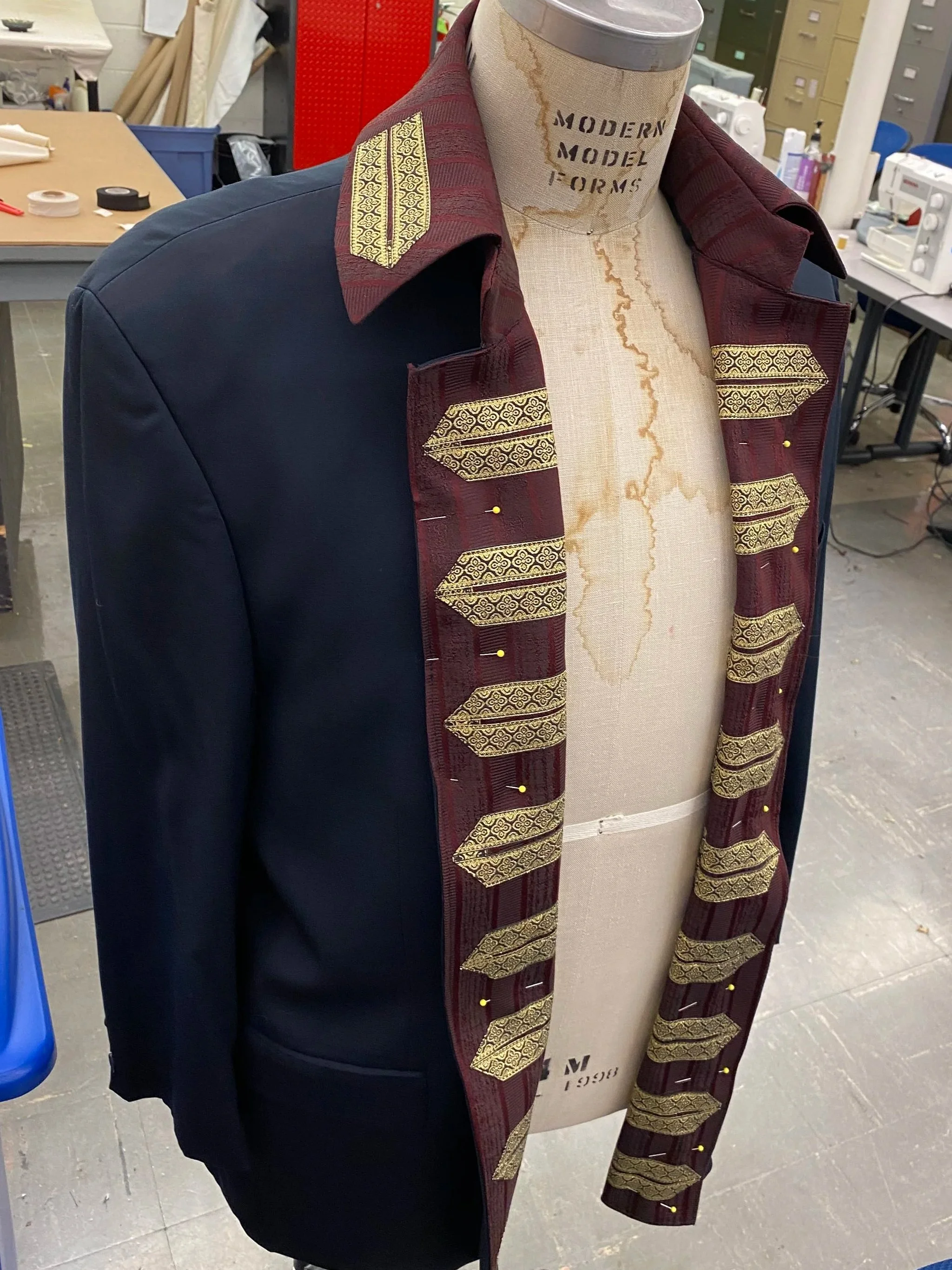  A blazer made to look more “period” by draping contrast fabrics and trims over the existing cut. 