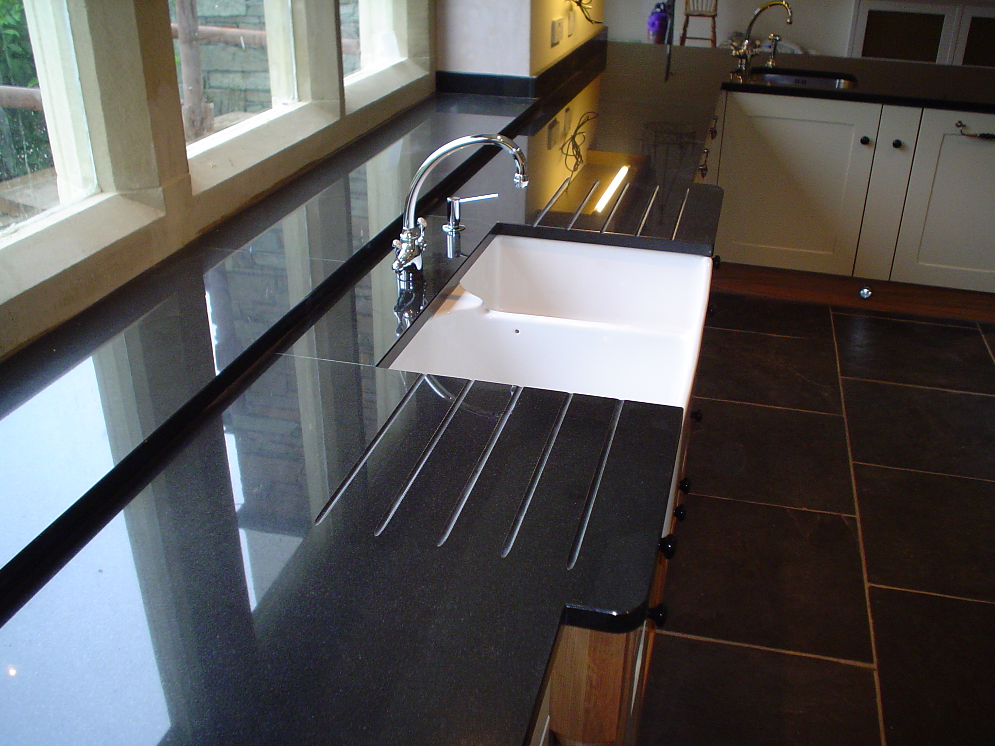 black-granite-worktop-with-belfast-sink-double-drainer-break-front.jpg