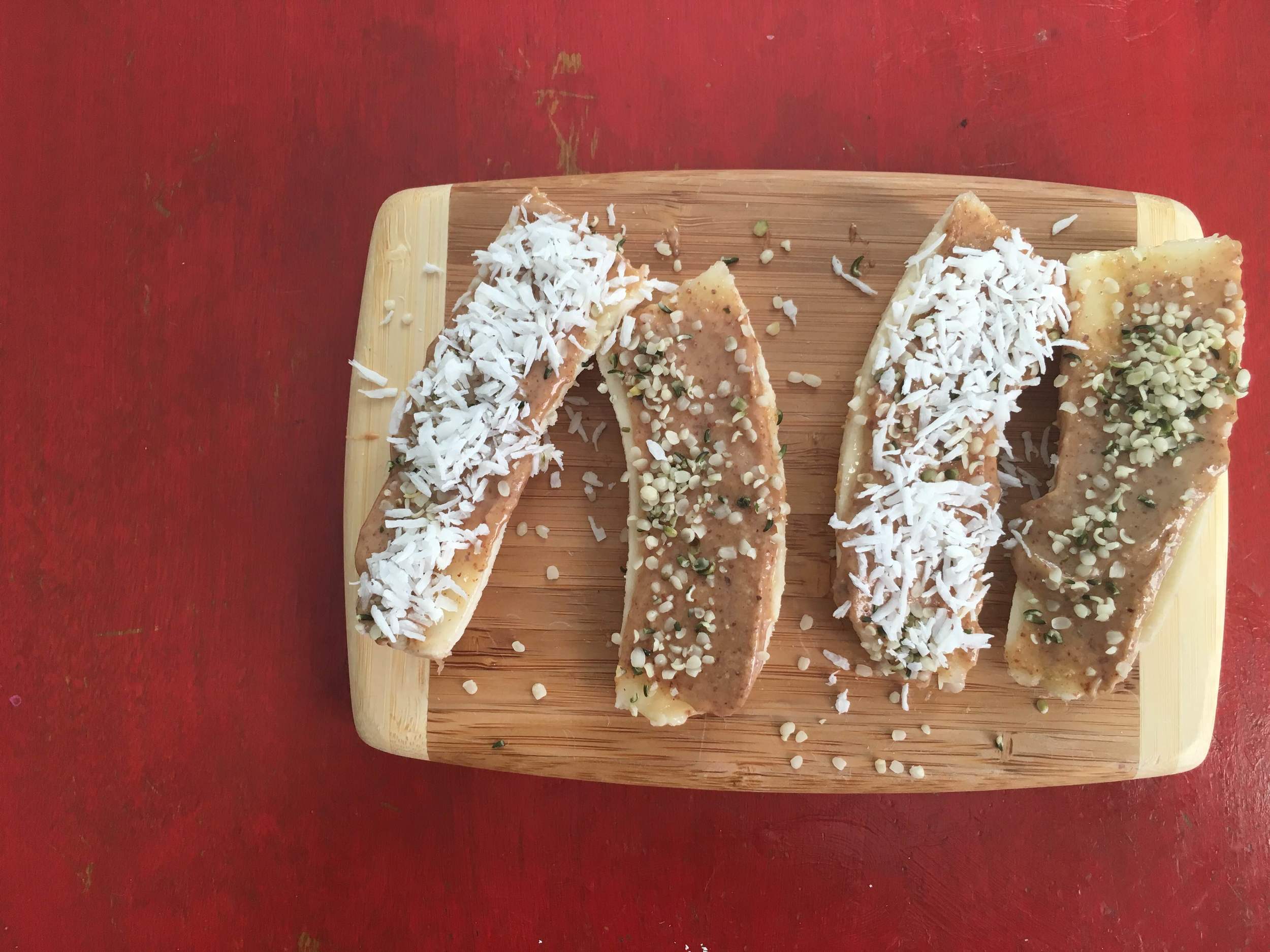 Banana Boats with almond butter, hemp seed and coconut flakes.
