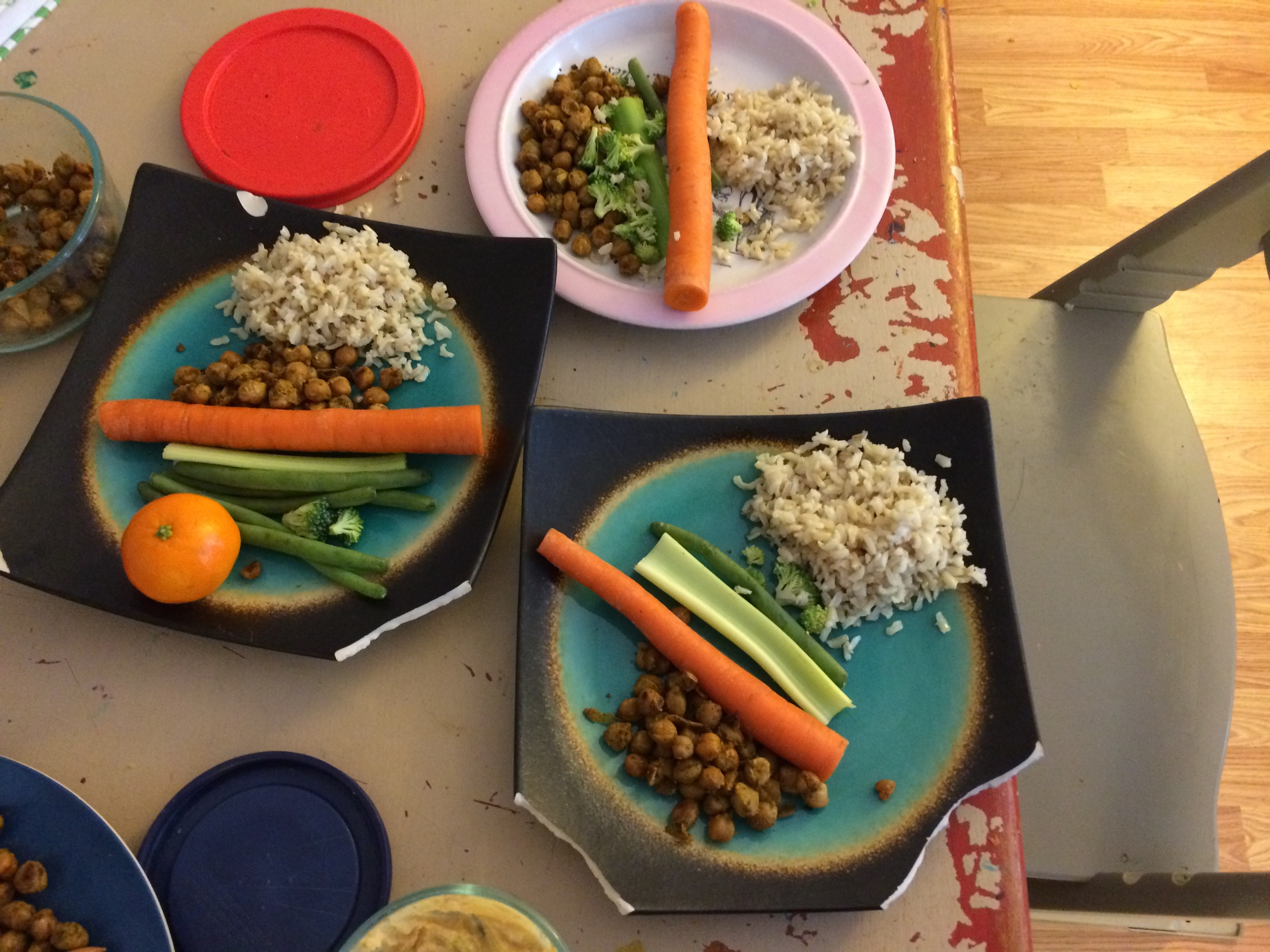 Judah's creation! Brown rice with olive oil and salt, leftover seasoned chickpeas, carrots, celery, greens and some extra vitamin C for a sick dad.