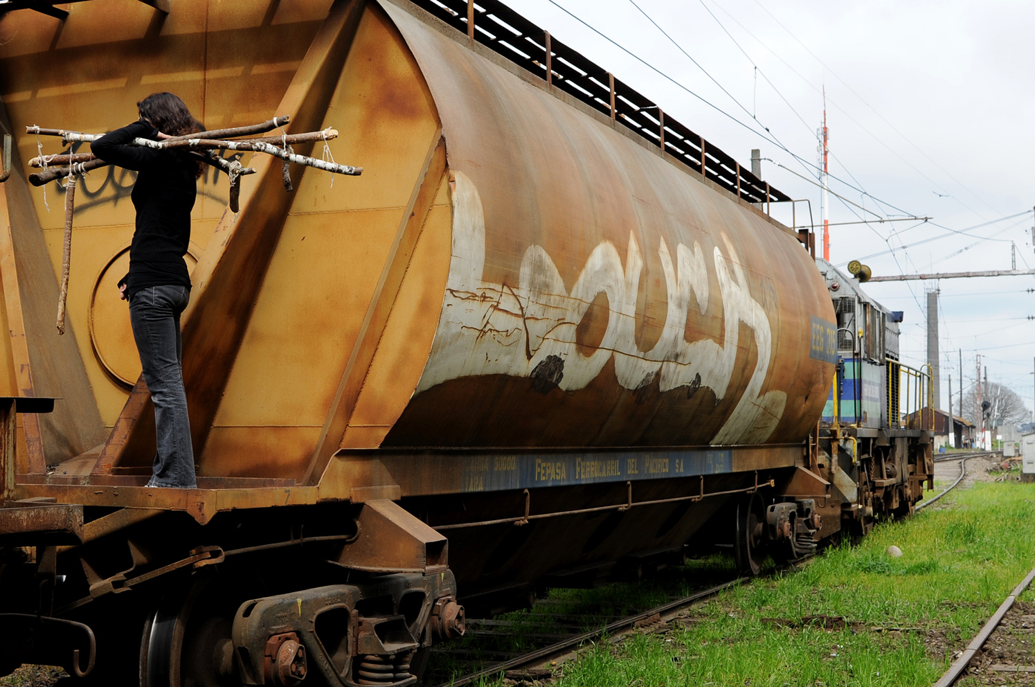 Estación de trenes . 2012. Fotografía de la serie de performance de caminatas con los palos: Caminatas, el cuerpo y la prótesis, 2010-2014. Impresión Lambda. 80 x 120 cm. Train station, 2012 . From the series of performance with the sticks: Walks, The Body and the Prosthetic, 2010-2014. Lambda print, 80 x 120 cm.