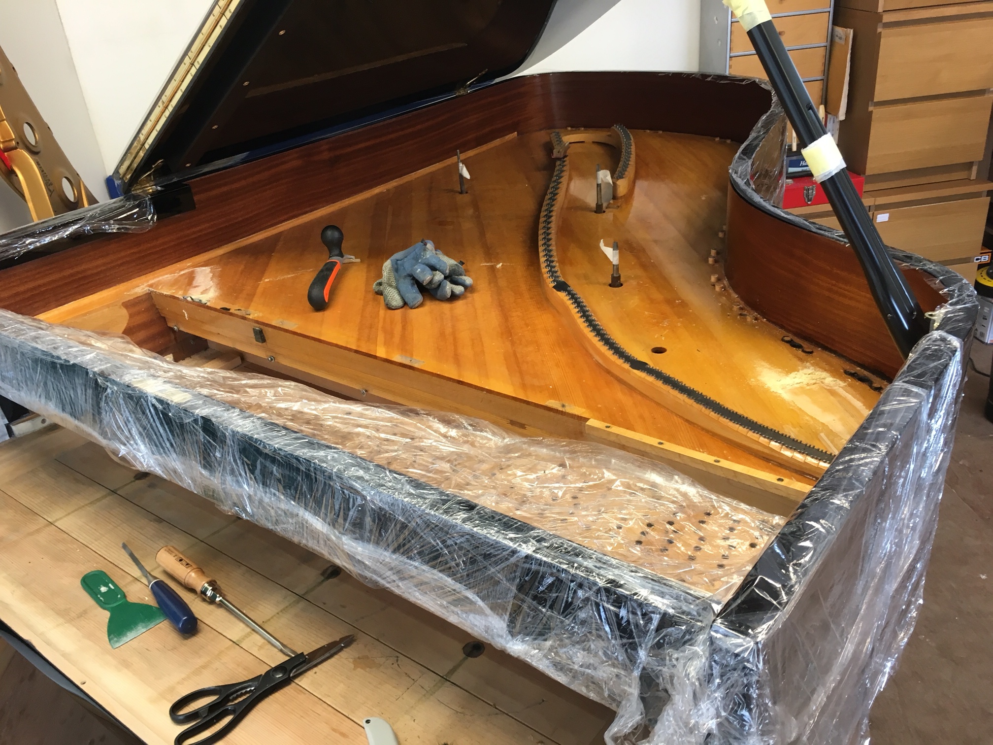 Preparing for the old soundboard varnish to be removed, prior to main lid being removed